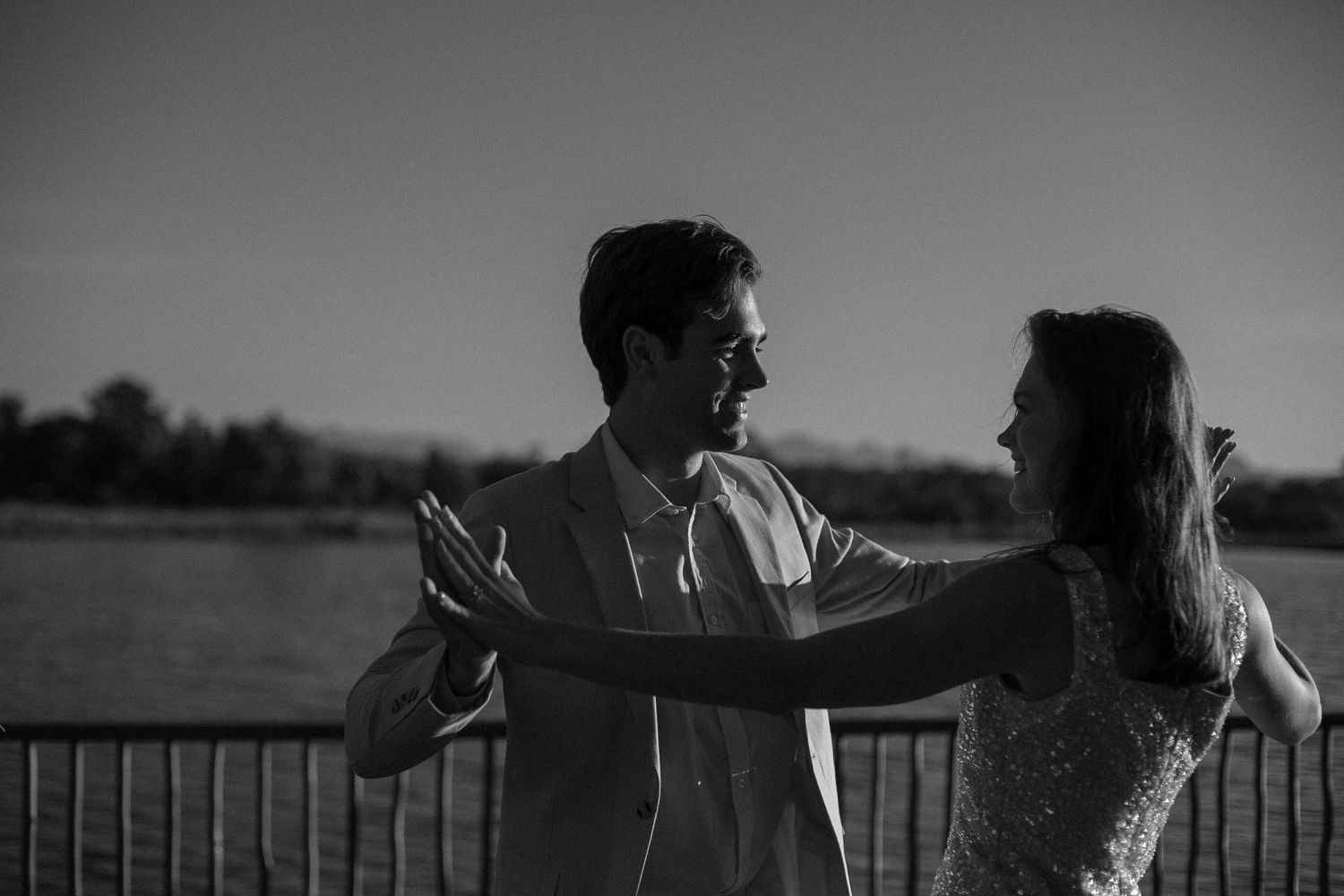 A elopement couple dancing, water in the background