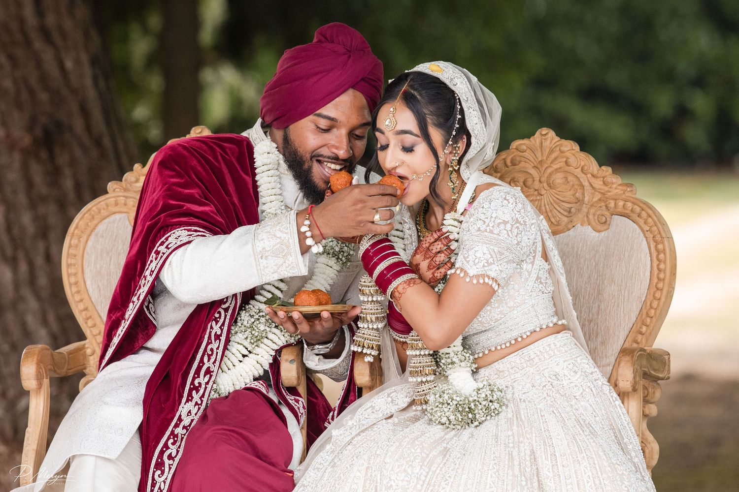 Bride and groom sharing sweets during an Asian wedding celebration