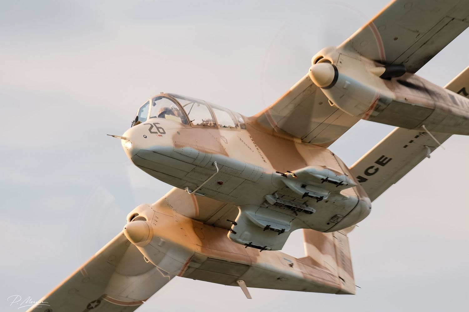 Vintage twin-boom military aircraft banking sharply during an airshow display flight.