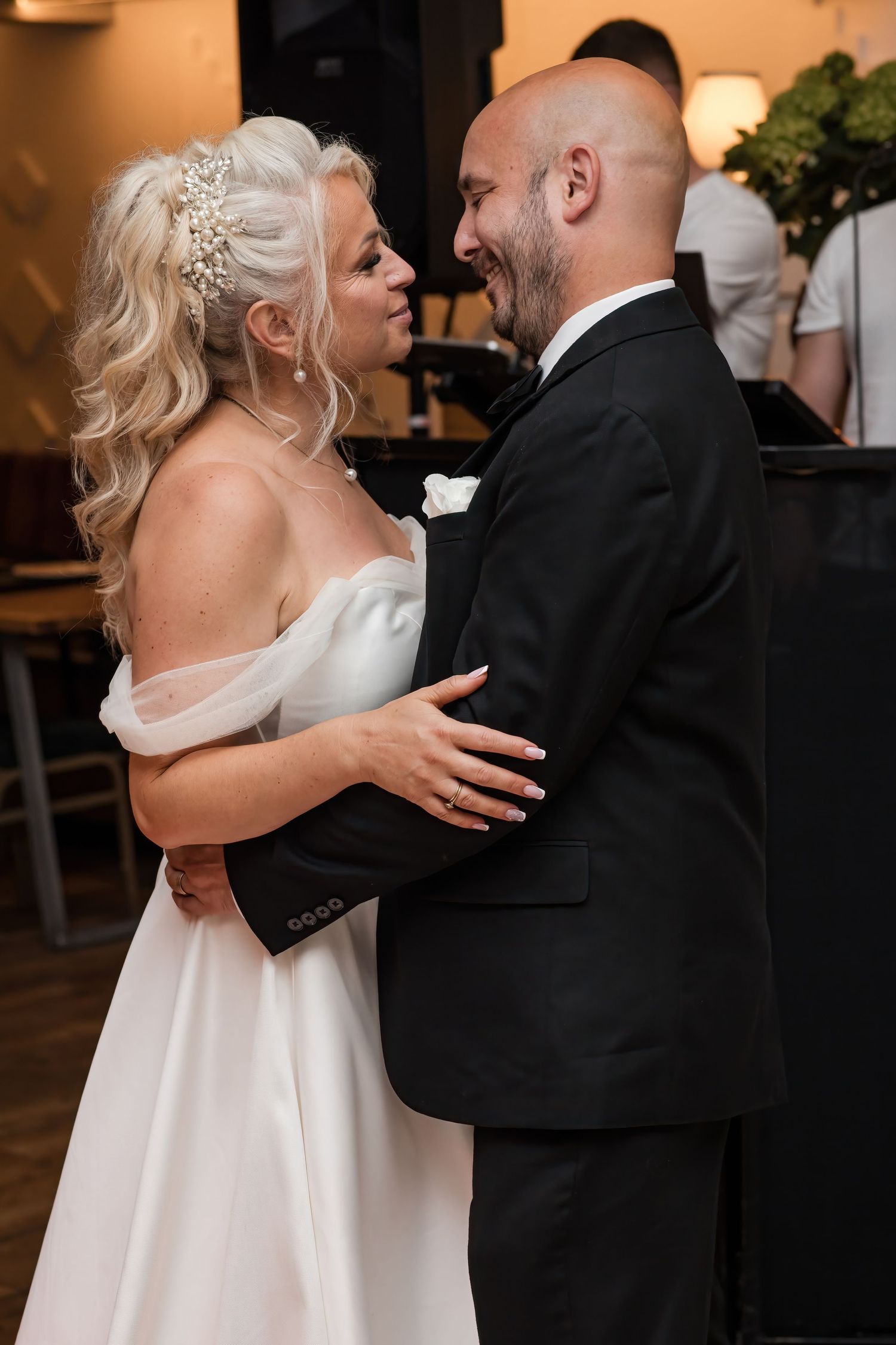 Smiling bride and groom share a joyful first dance moment at their elegant wedding reception.