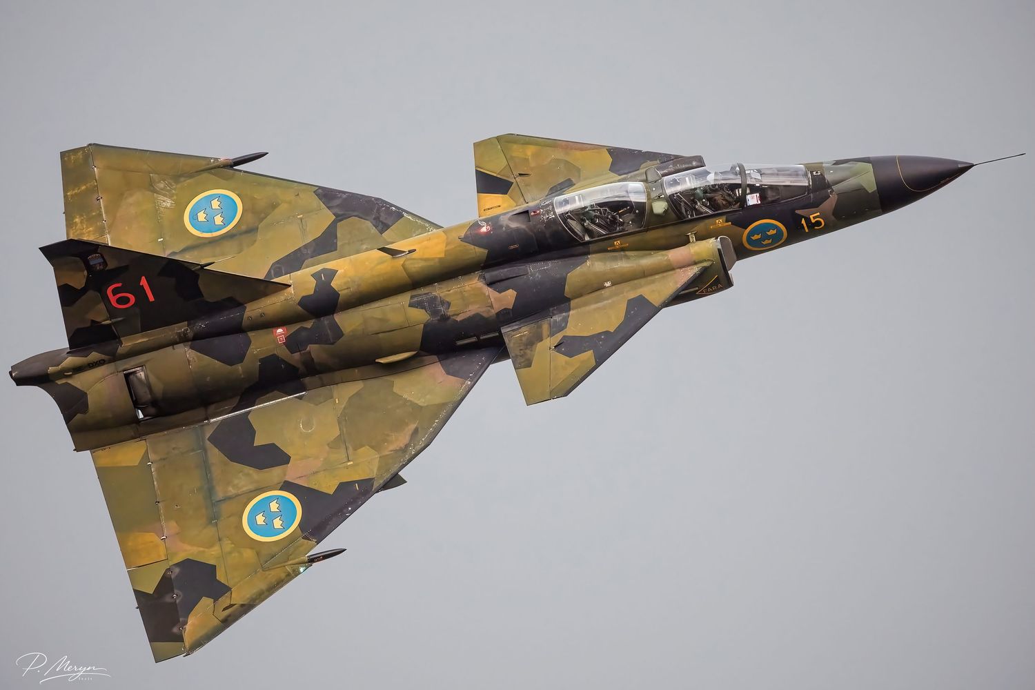 Swedish Air Force Saab Viggen jet number 61 in yellow-green camouflage performing aerobatics.