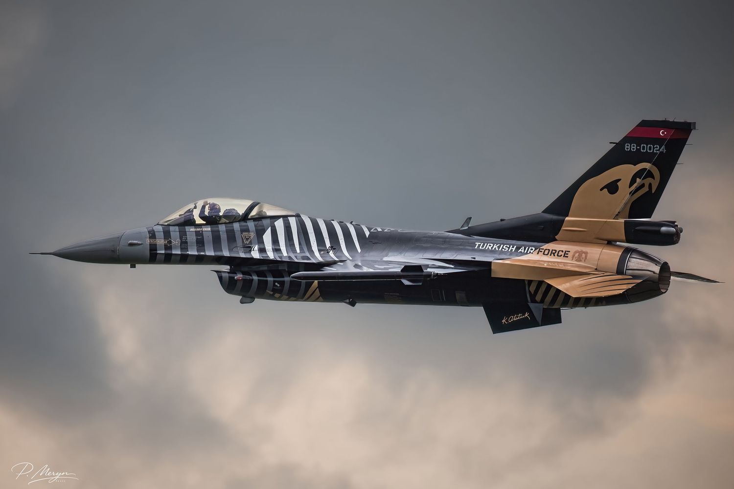 Turkish Air Force Solo Turk F-16 fighter jet flying against dramatic cloudy sky.