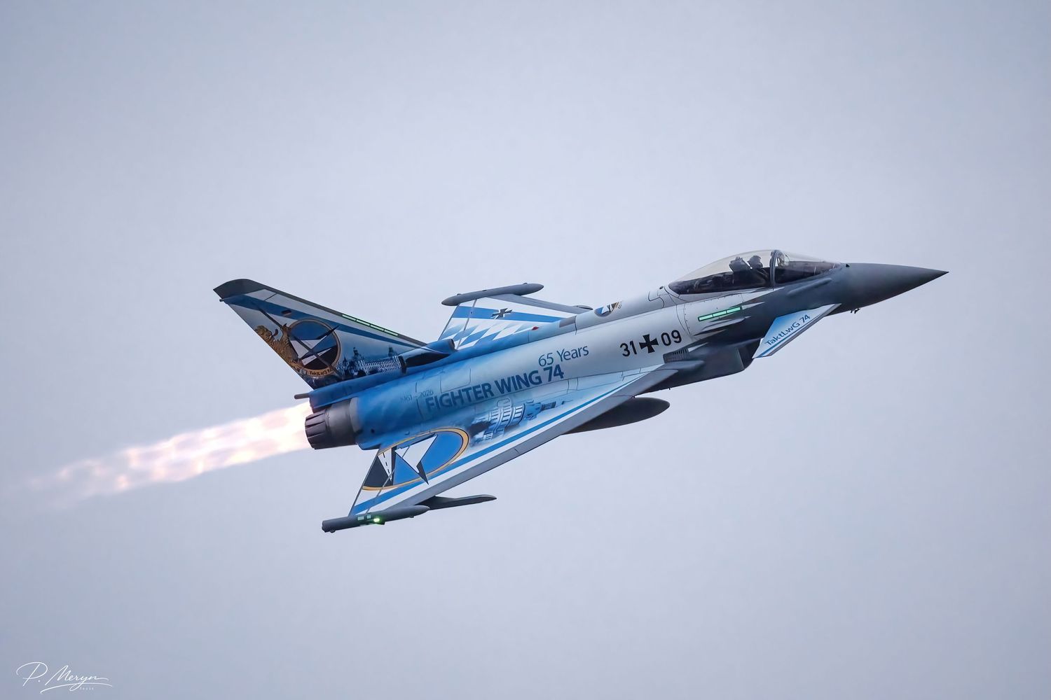 Eurofighter Typhoon in stunning blue special livery performing afterburner climb at military airshow display.