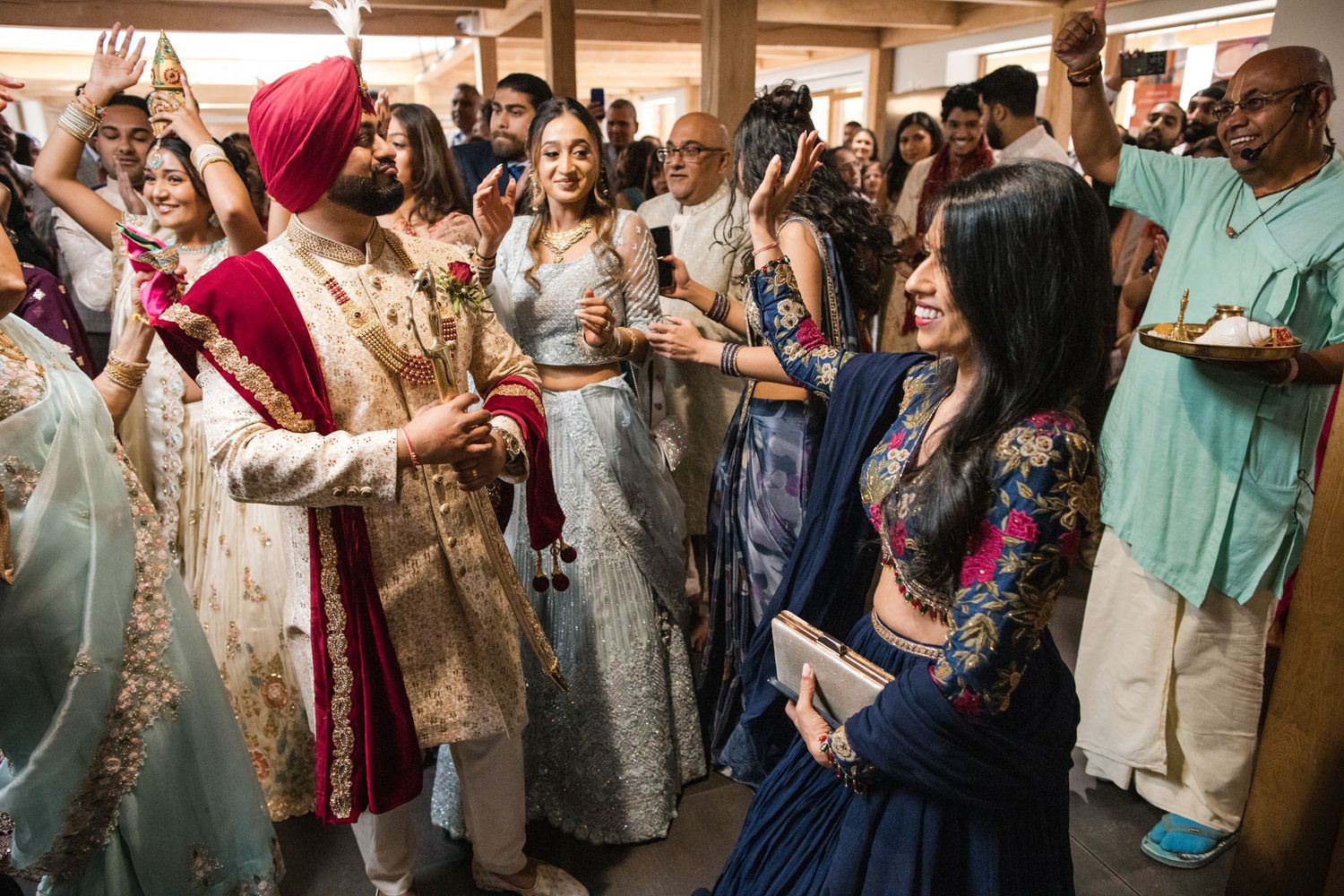 Groom celebrating with family and wedding guests during an Asian wedding