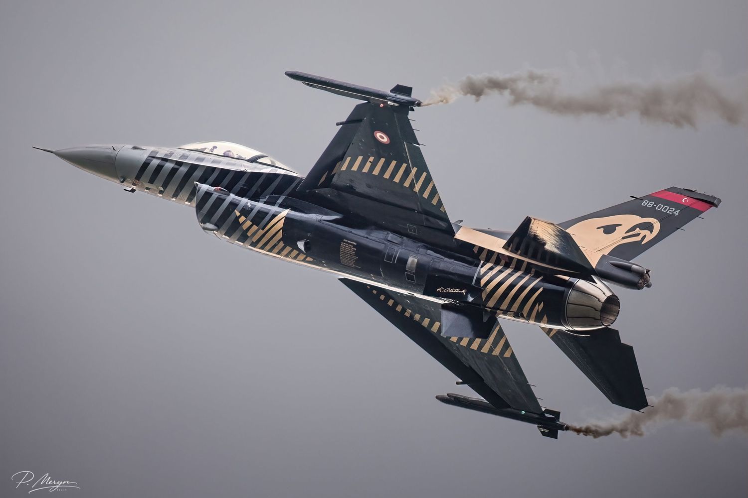 Turkish Air Force F-16 fighter jet performing aerobatic maneuvers at airshow with smoke trails.