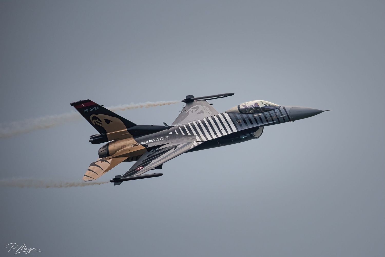 Turkish Air Force F-16 Solo Turk in distinctive gold and silver livery performing high-speed airshow pass.