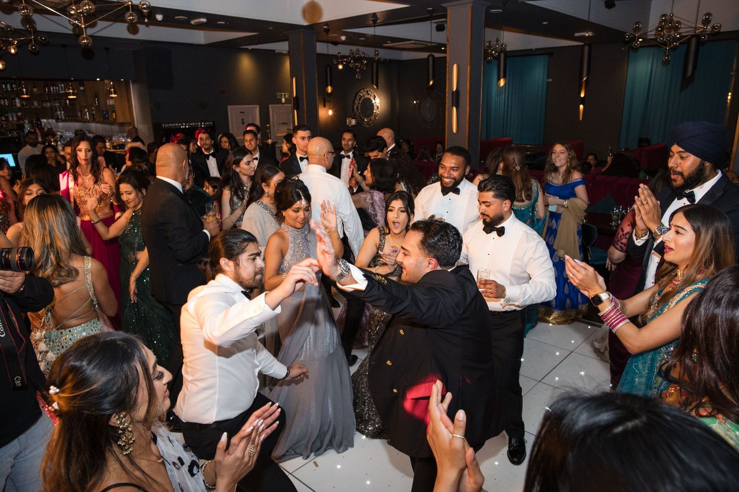 Elegant wedding reception guests dancing and celebrating together in a beautifully decorated venue.