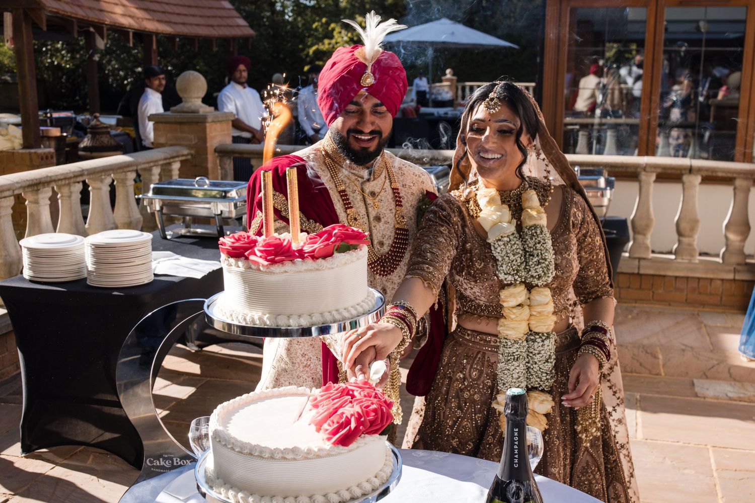 Bride and groom standing beside their wedding cake