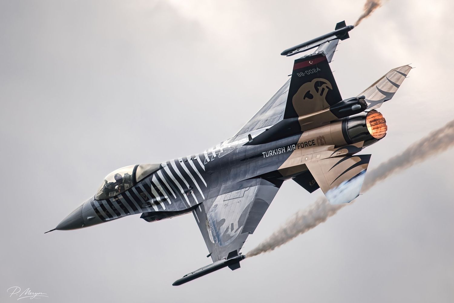 Turkish Air Force F-16 Solo Turk with decorative livery banking sharply at airshow.