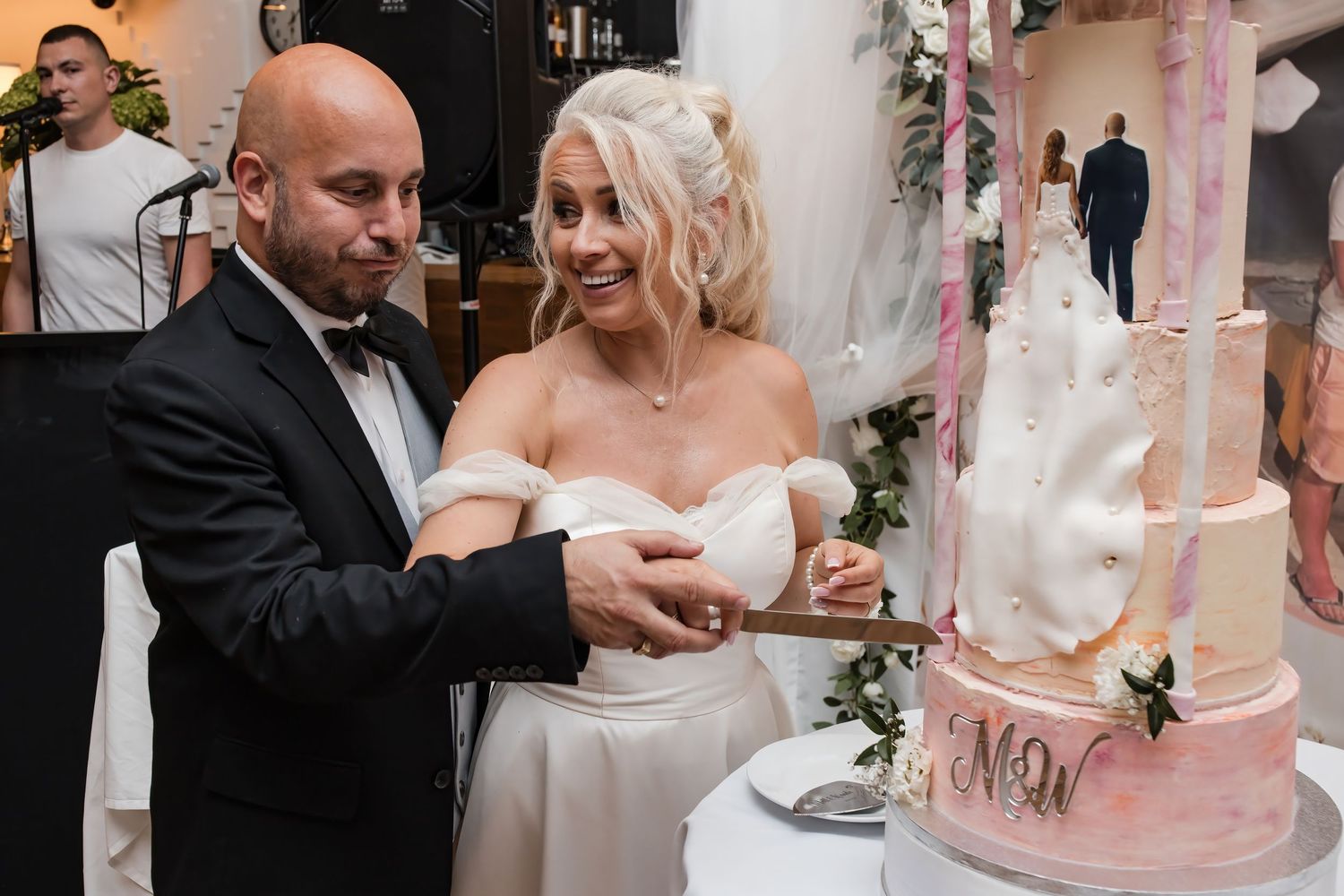 Bride and groom cut their beautiful marble and pink wedding cake together at their reception.