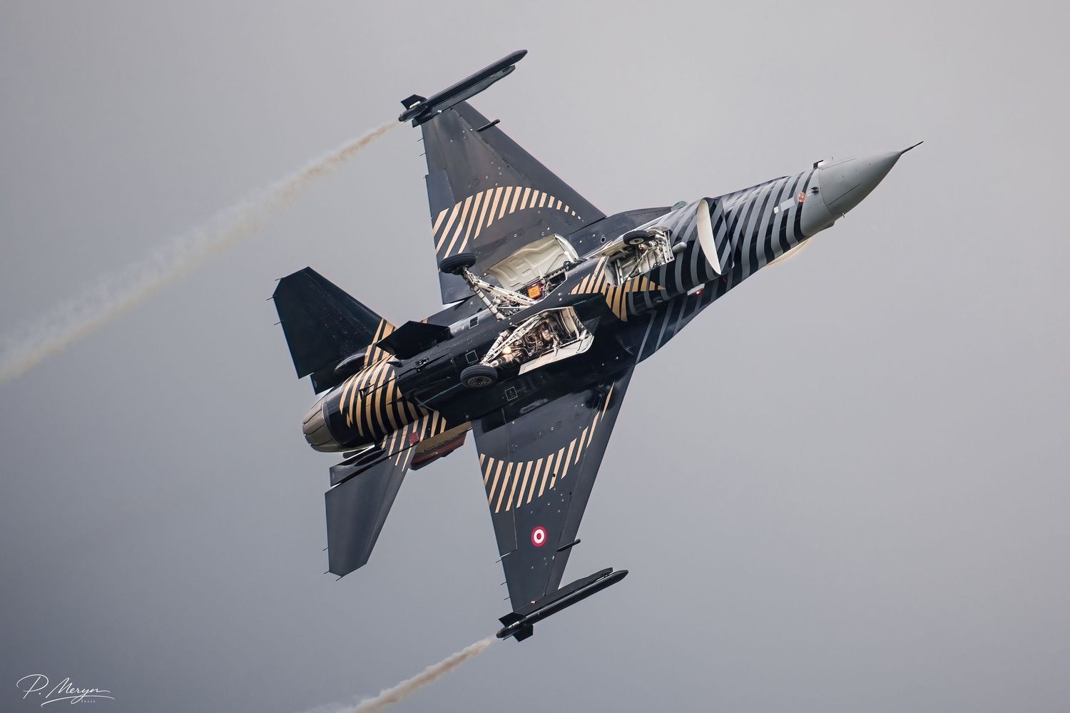 Turkish Air Force F-16 with distinctive black and gold livery performing steep climb maneuver.