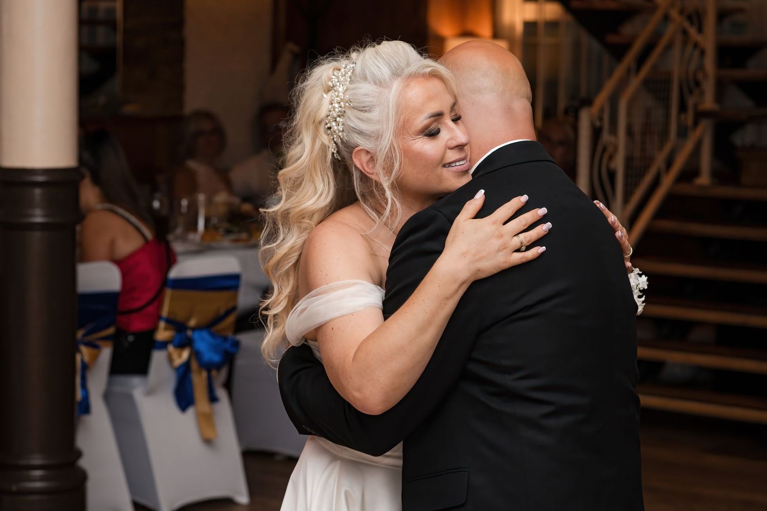 Bride and groom share an emotional slow dance embrace at their wedding reception.