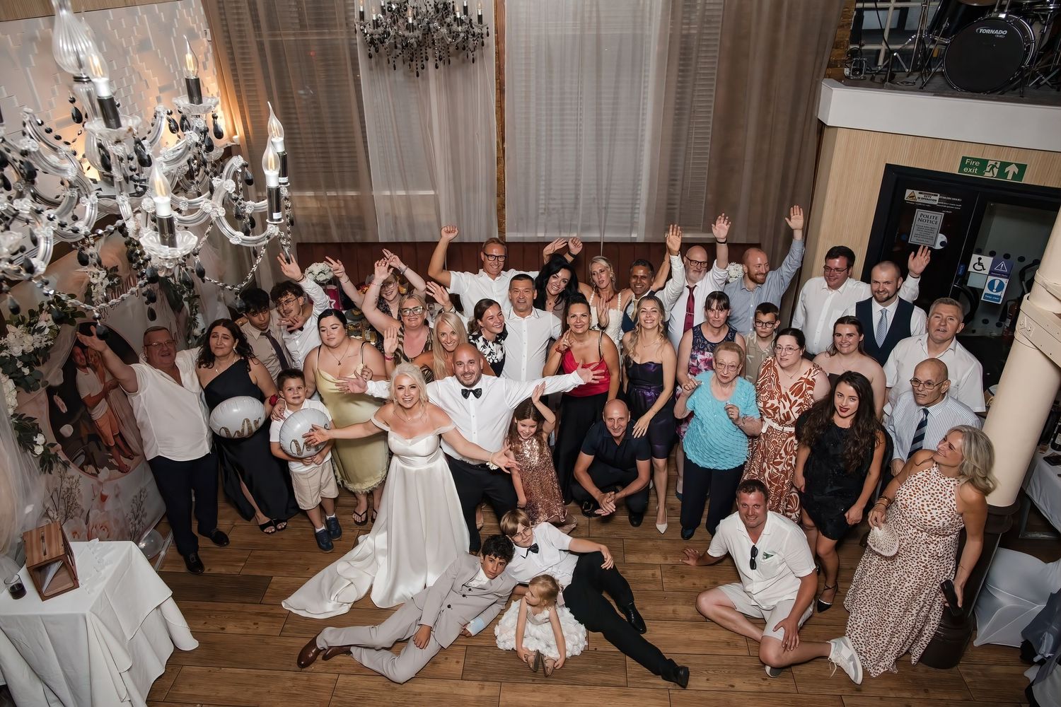 Aerial view of bride, groom and wedding guests celebrating together on the dance floor.
