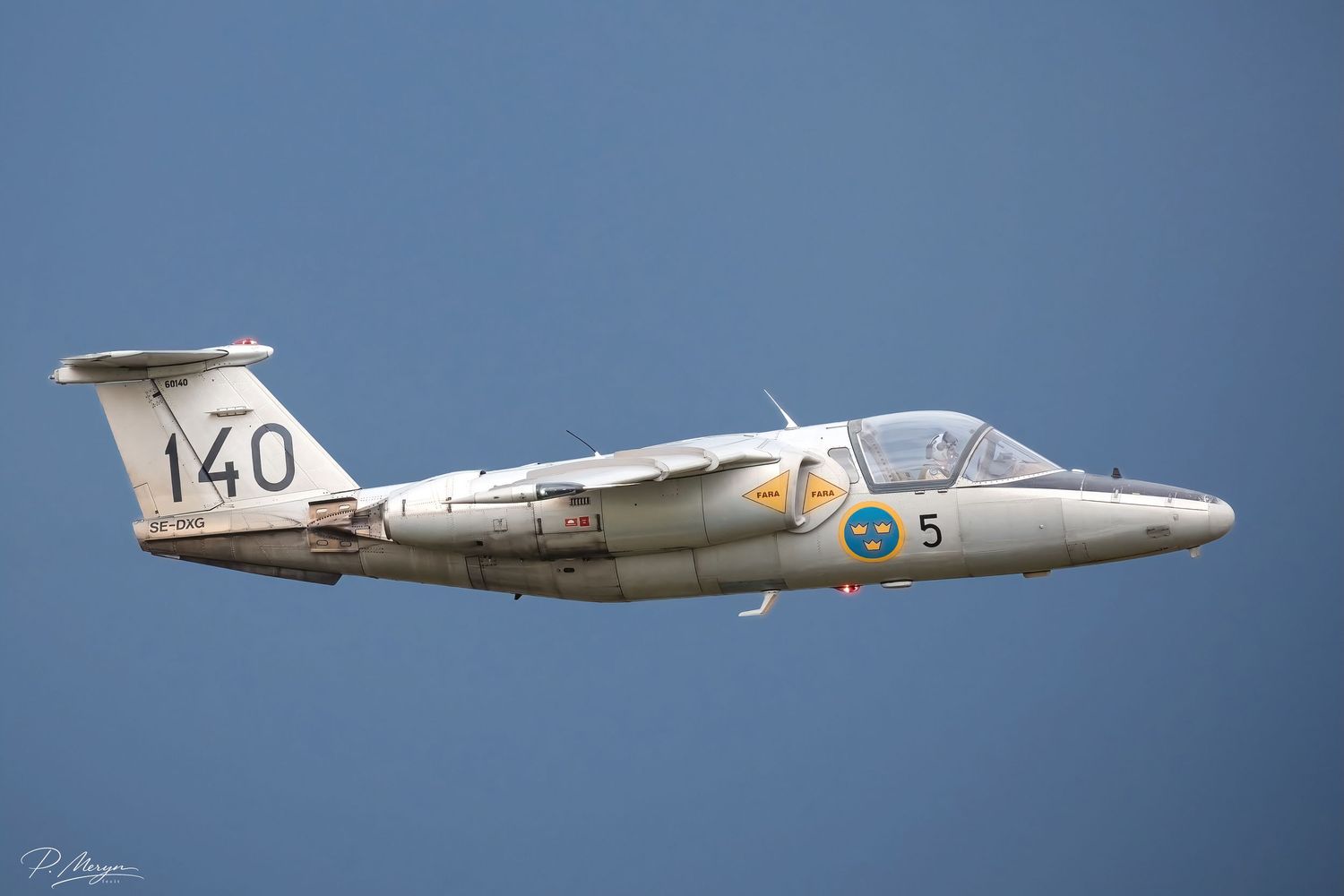 A Swedish Air Force Saab 105 jet trainer numbered 140 flies against a clear blue sky.