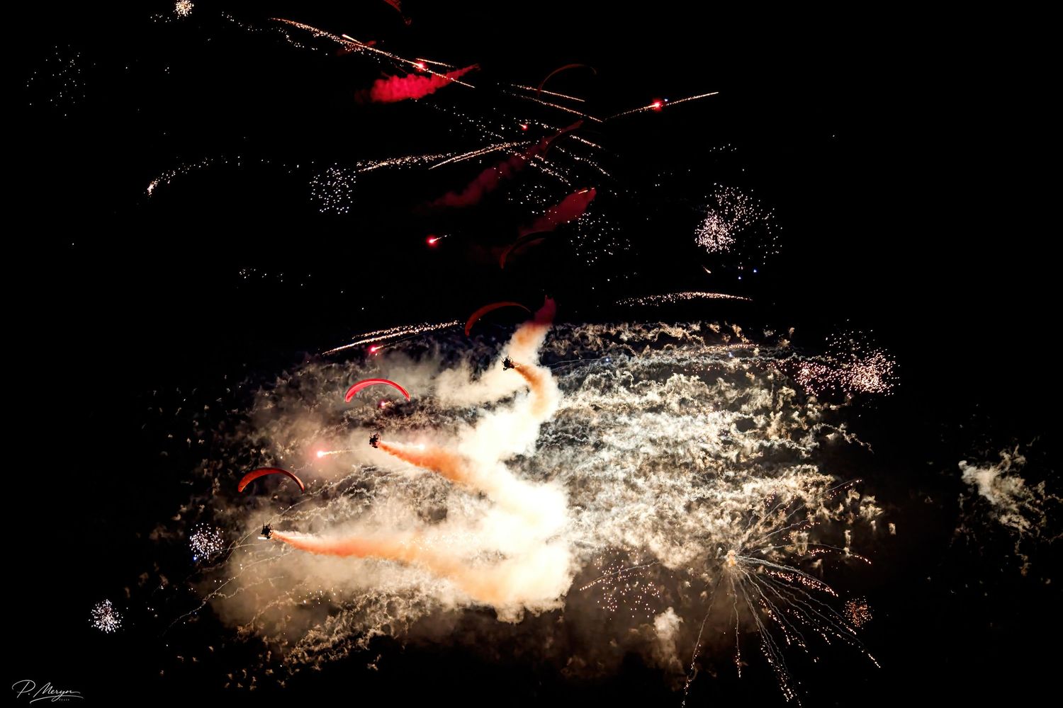 Colorful fireworks explode in a dazzling nighttime pyrotechnic display with bright sparks and smoke.