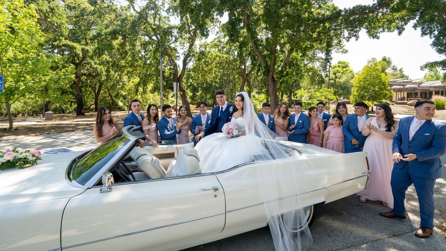 Bride and wedding party posing by vintage white convertible at outdoor wedding in Sacramento, The Padillas Wedding Photography