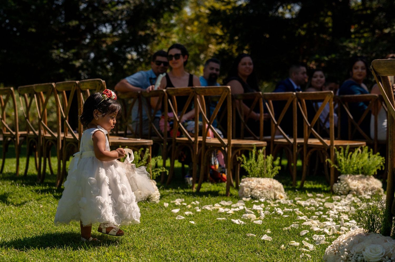 Flower girl walking outdoor aisle at The Ranch at Lone Oak wedding, candid ceremony moment Sacramento wedding photography