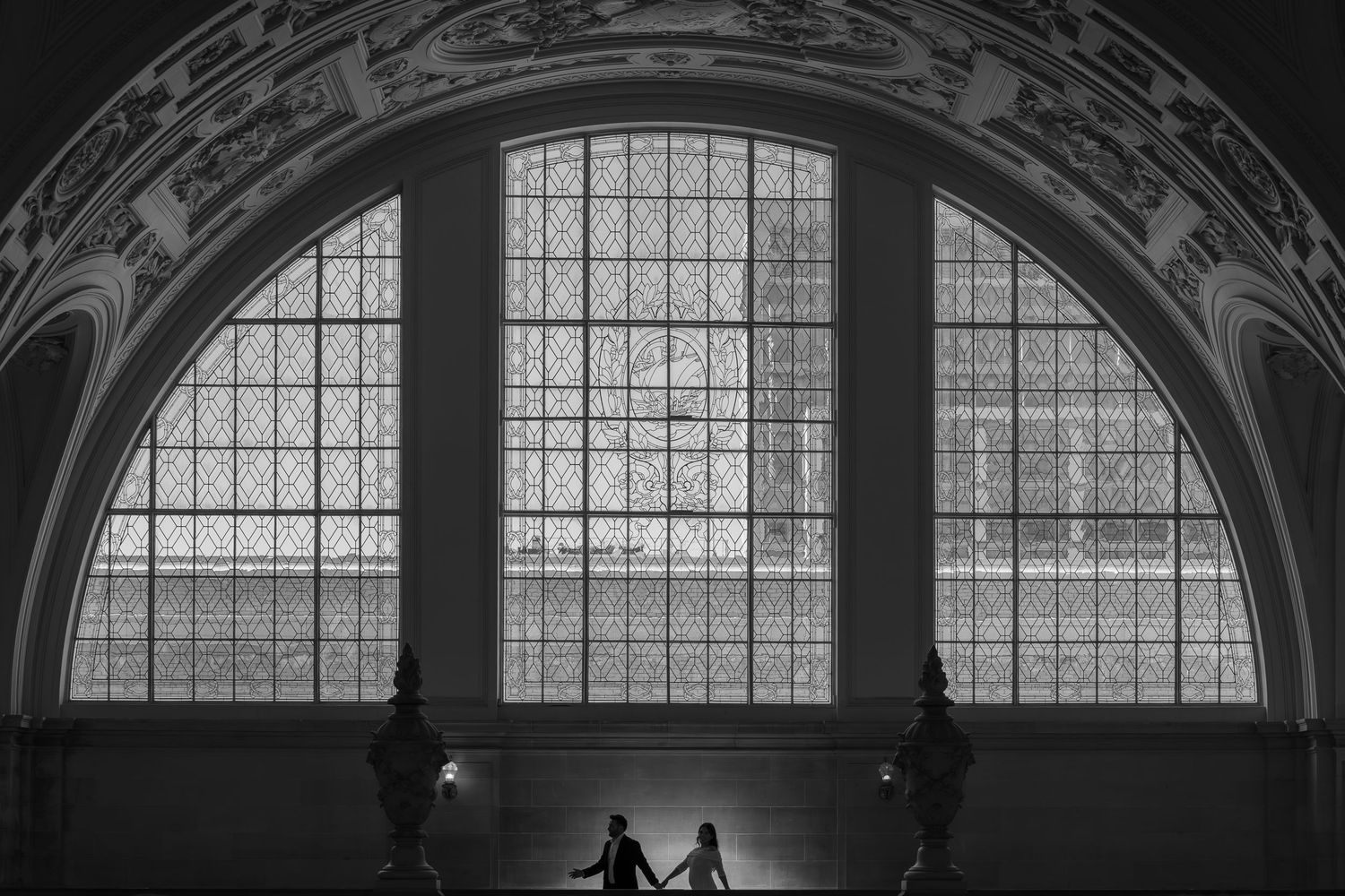 Bride and groom silhouette in front of grand arched window at San Francisco City Hall, luxury elopement photography by The Padillas