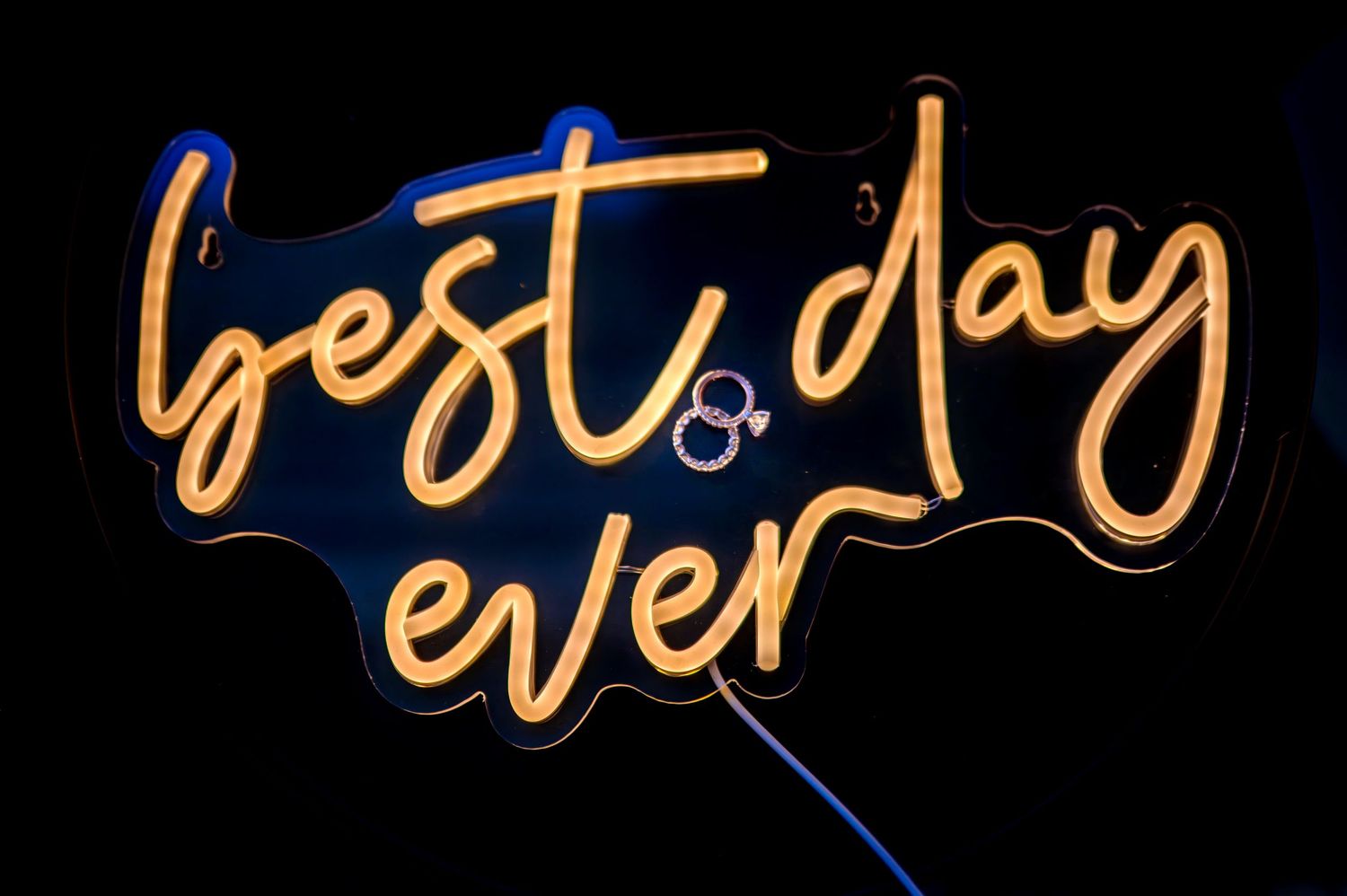 Neon wedding sign ‘Best Day Ever’ with engagement ring displayed, wedding reception decor by Sacramento photographers The Padillas