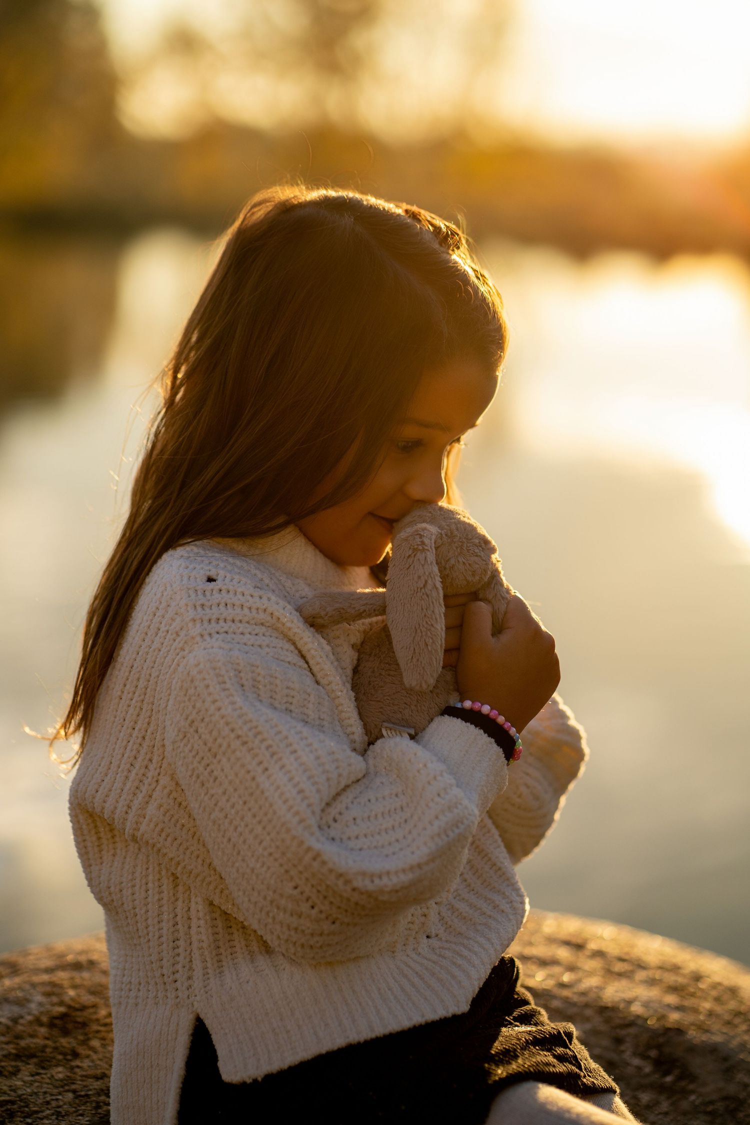 Little girl hugs stuffed bunny at Bywater Hollow in Lincoln, CA. Family photography session at sunset.