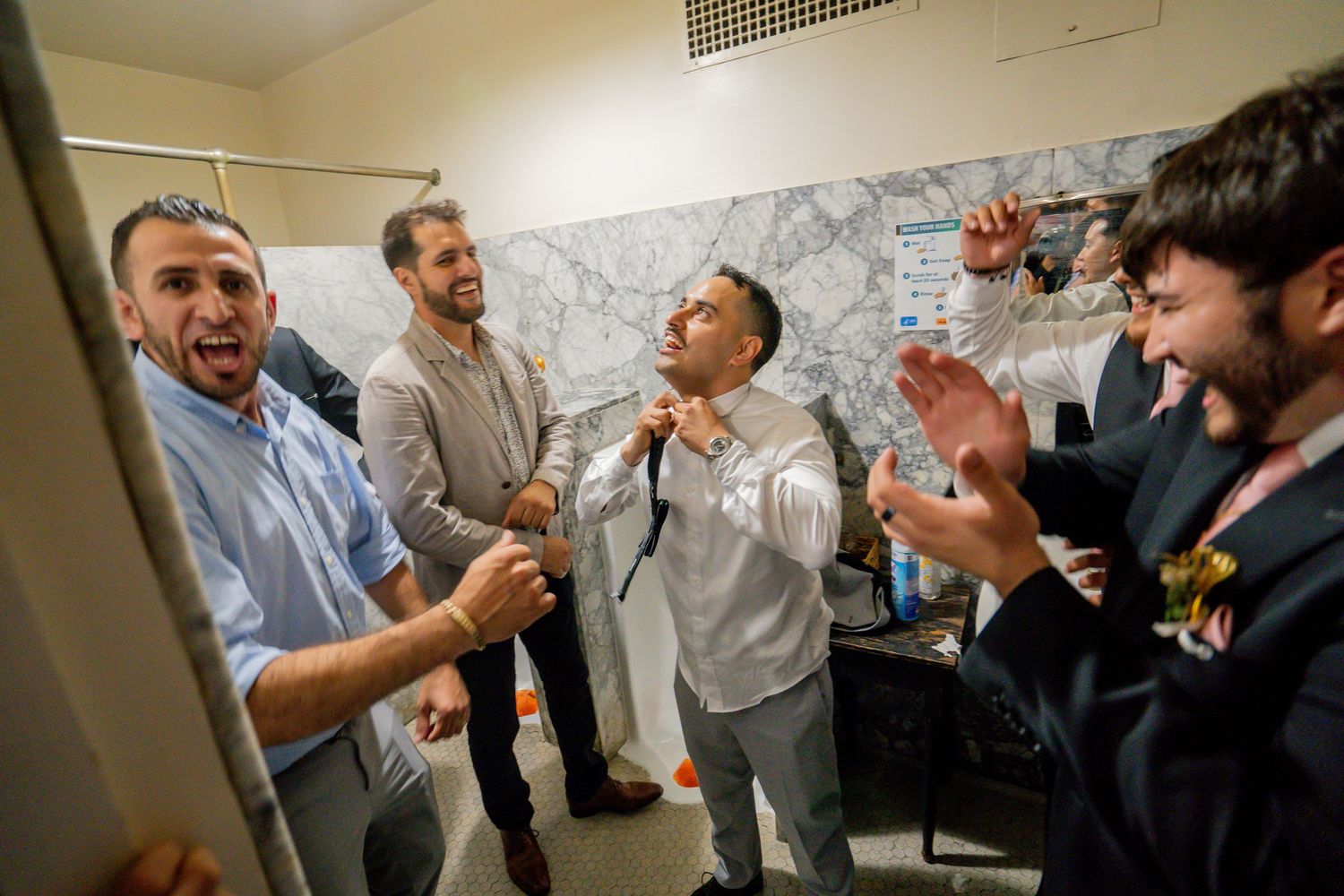 Groom getting ready with groomsmen before wedding at Sacramento Masonic Temple, documentary wedding photography by The Padillas.