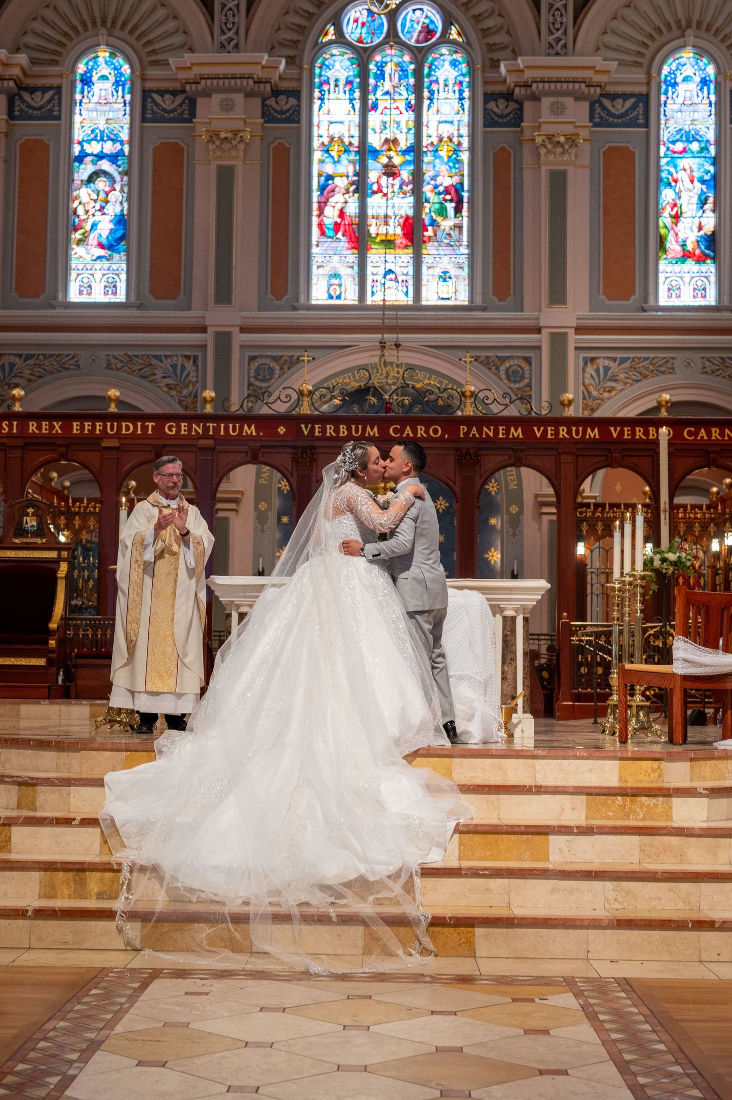 Bride and groom first kiss on altar at Cathedral of the Blessed Sacrament Sacramento, beautiful Mexican Catholic wedding captured by The Pa