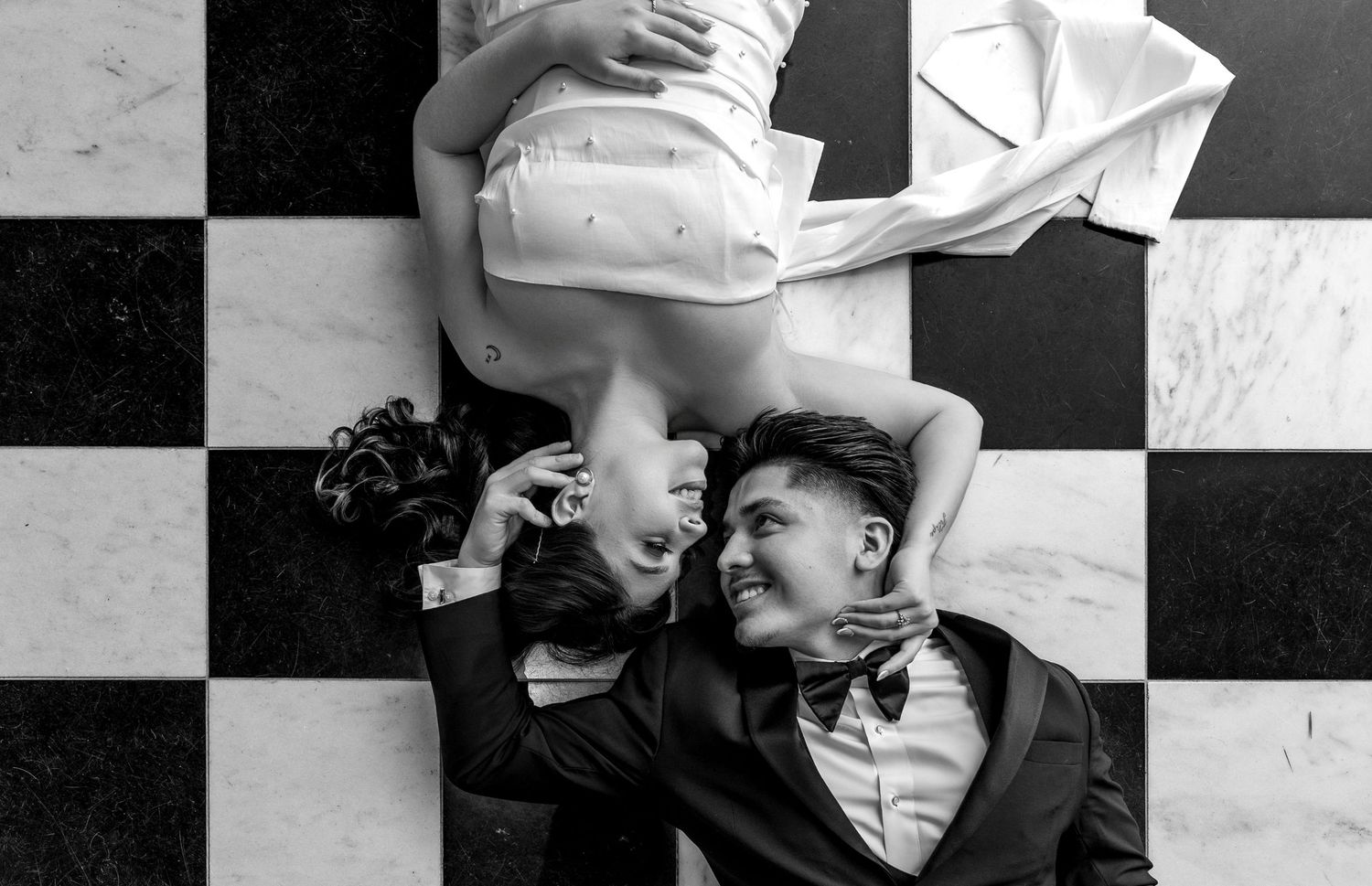 Editorial black and white engagement couple laying on checkered floor in downtown Sacramento