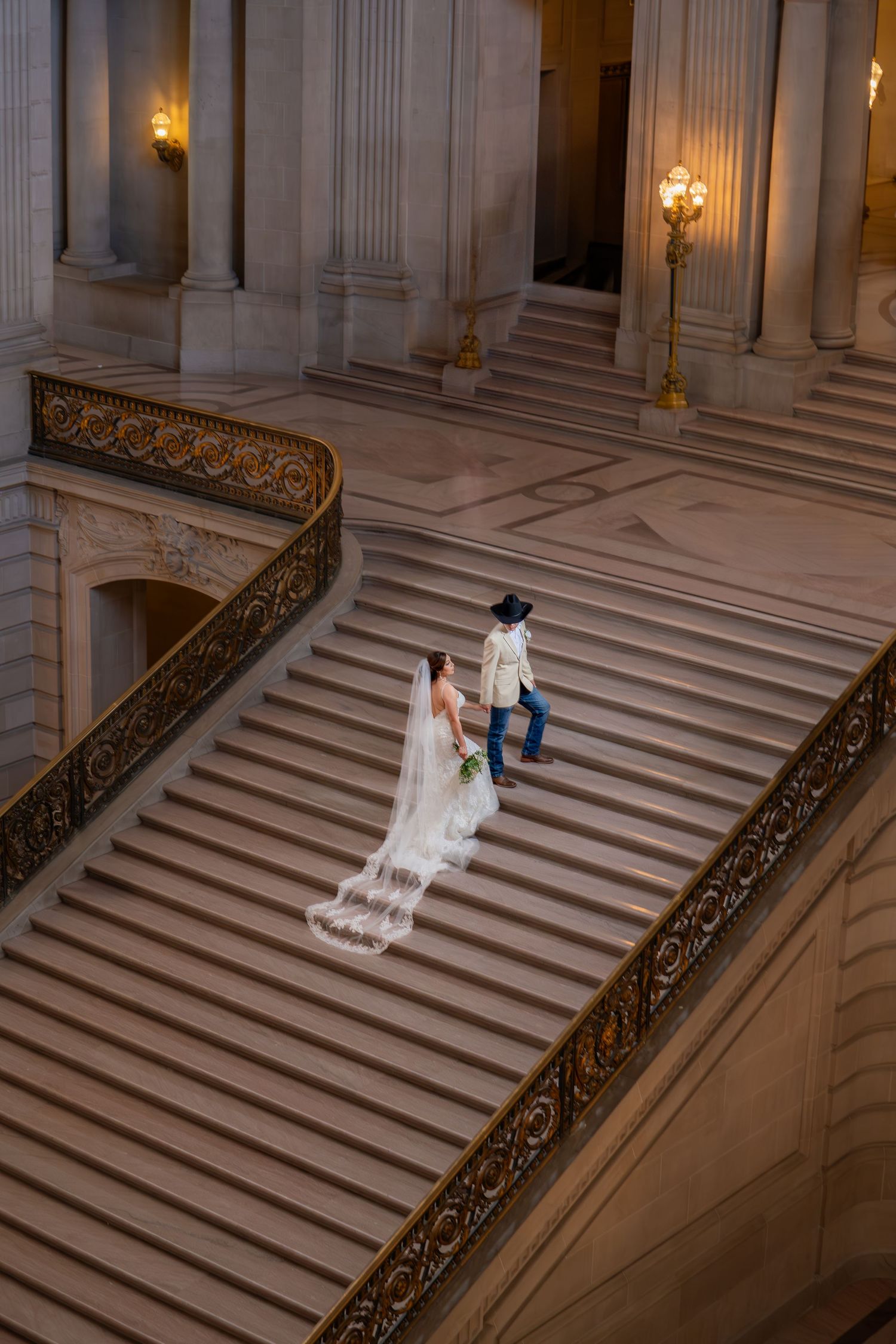 Bride and groom on grand staircase at San Francisco City Hall, Western style elopement captured by The Padillas Studio