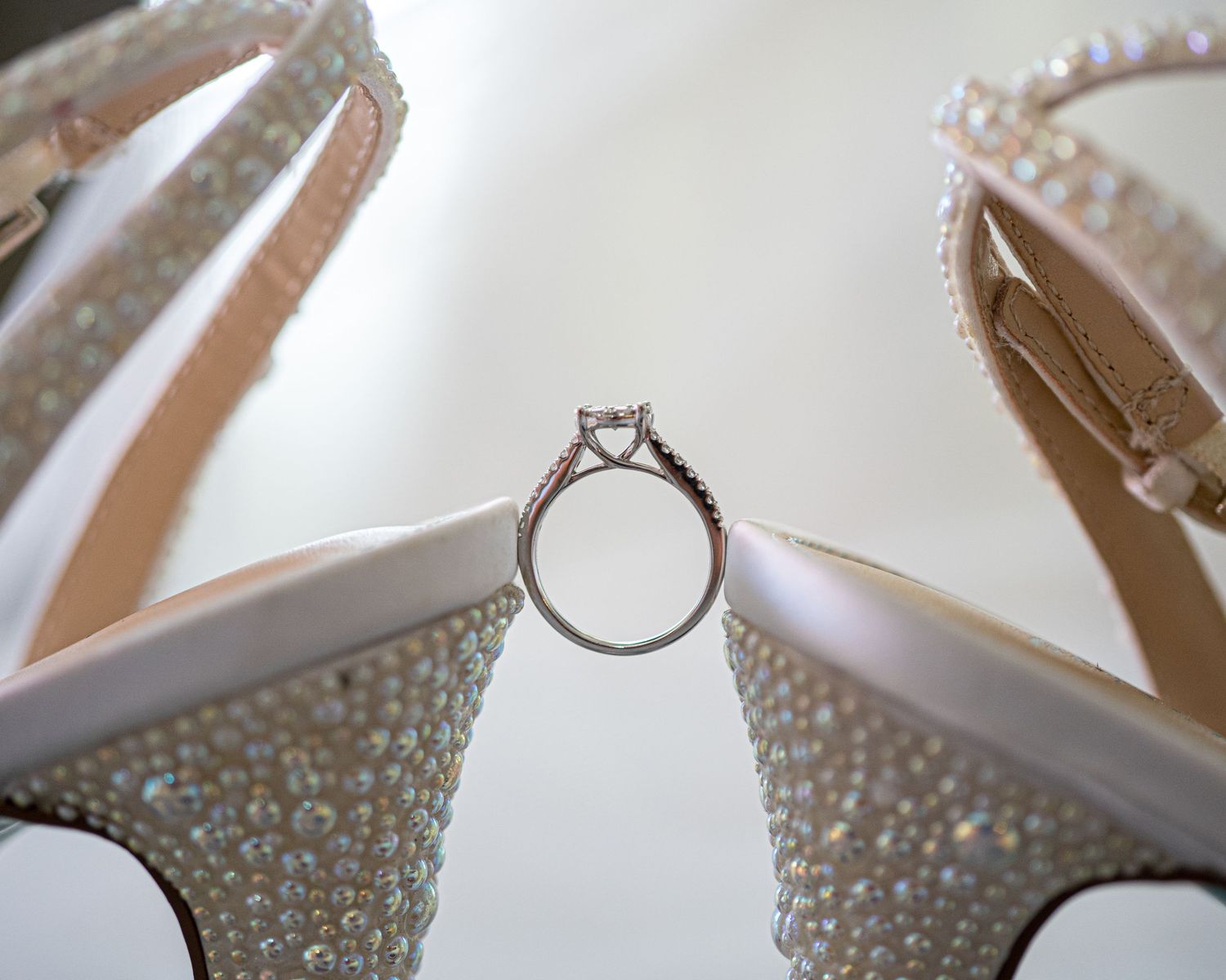 Engagement ring placed between crystal bridal heels, luxury Sacramento wedding detail photography by The Padillas