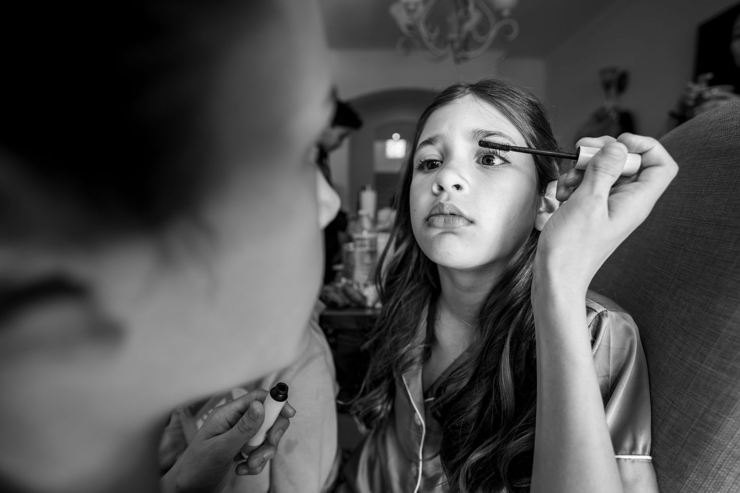 Quinceañera damas getting makeup done during getting ready candid
