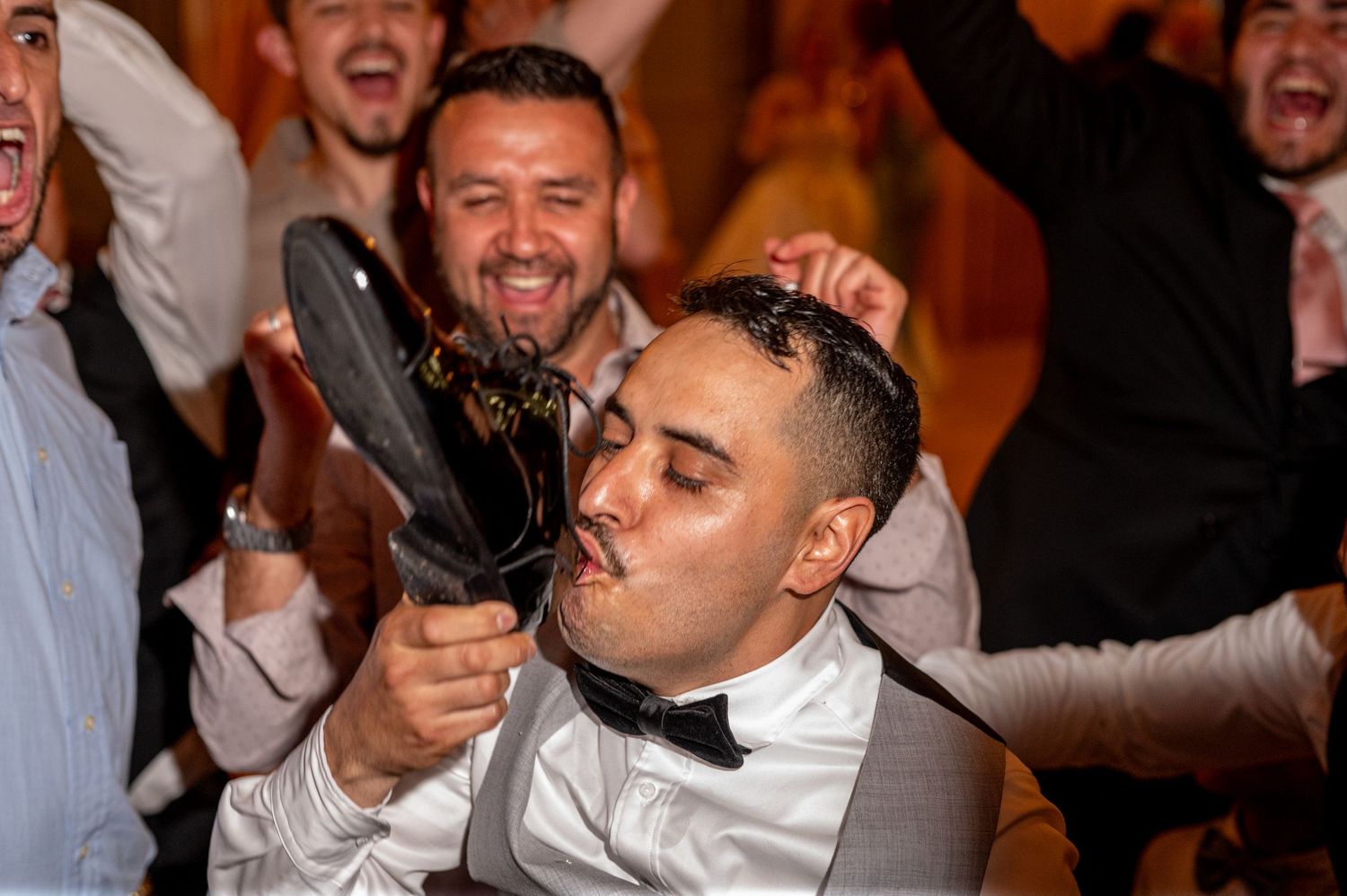 Groom drinking from shoe during wedding party celebration, traditional Mexican wedding reception in Sacramento by The Padillas.