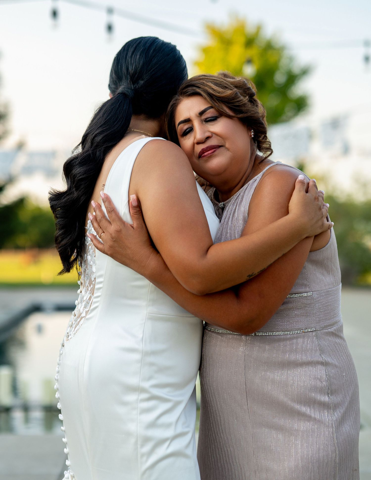 Bride and mother share emotional hug during outdoor wedding at The Ranch at Lone Oak, captured by The Padillas.