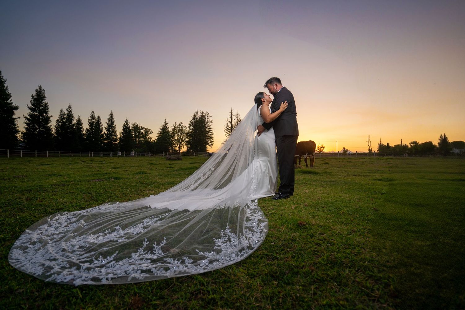 Romantic sunset wedding portrait with bride’s long veil at The Ranch at Lone Oak, captured by The Padillas.