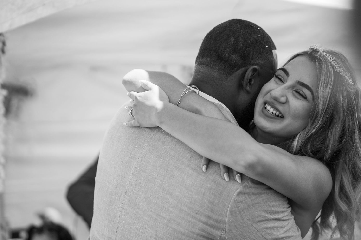 Bride hugging groom with big smile during Sacramento backyard wedding, candid moment captured by The Padillas.