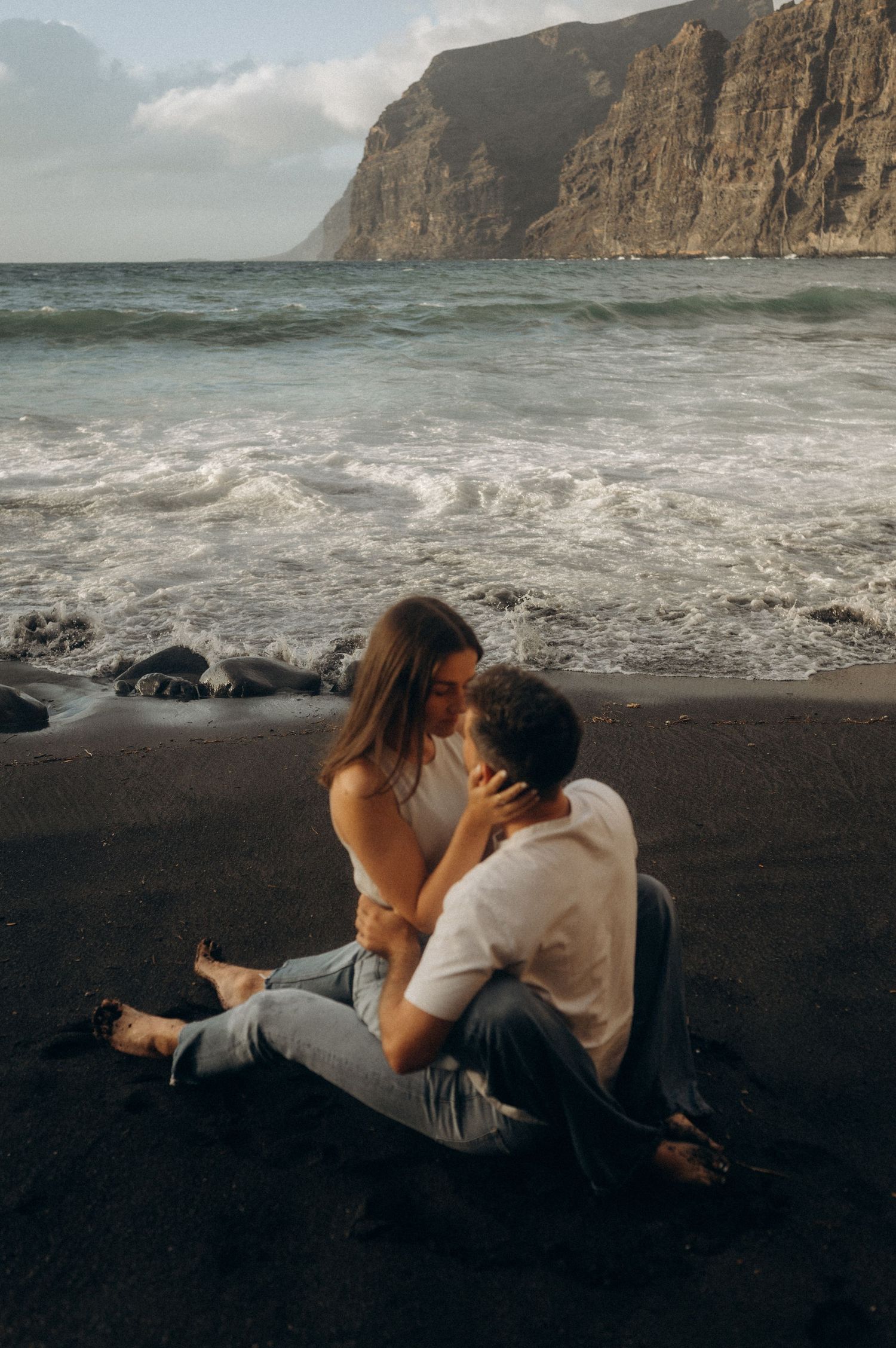 Young couple in love looking into each other’s eyes on Playa de Los Guíos, Tenerife cliffs