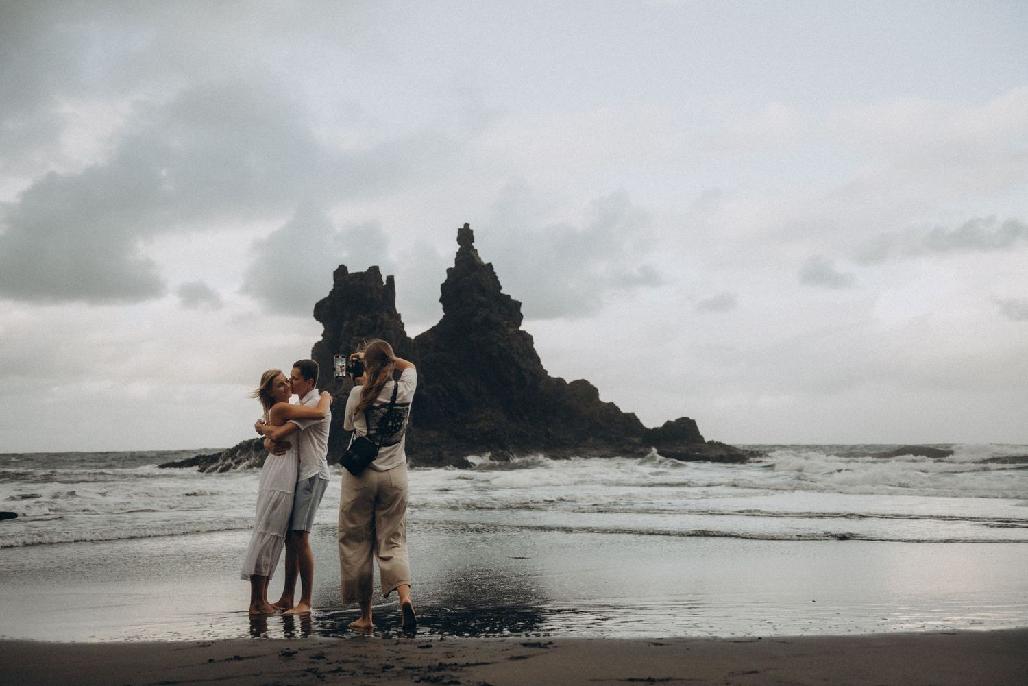 Young couple holding hands and enjoying romantic moment on Playa Benijo, Tenerife
