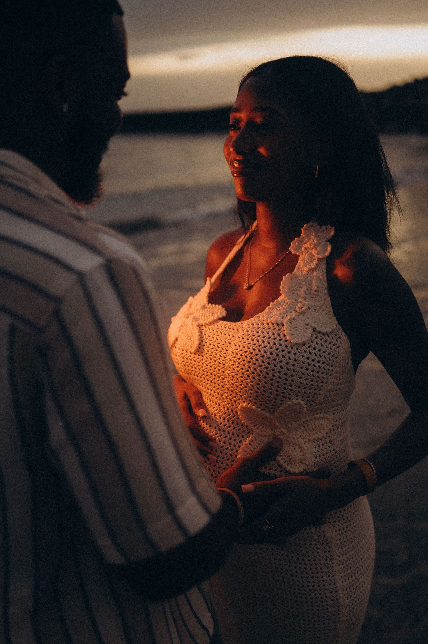 Maternity pose with couple facing each other and holding hands