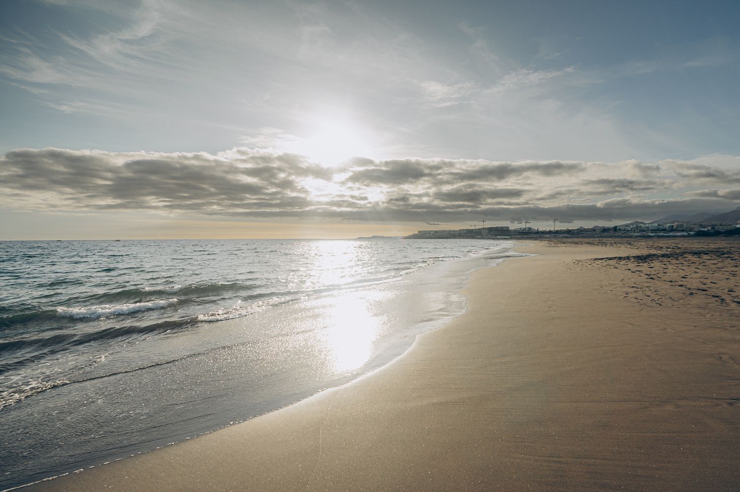 Scenic view of dark sandy beach at Playa La Tejita, Tenerife with Atlantic Ocean and sunset in background