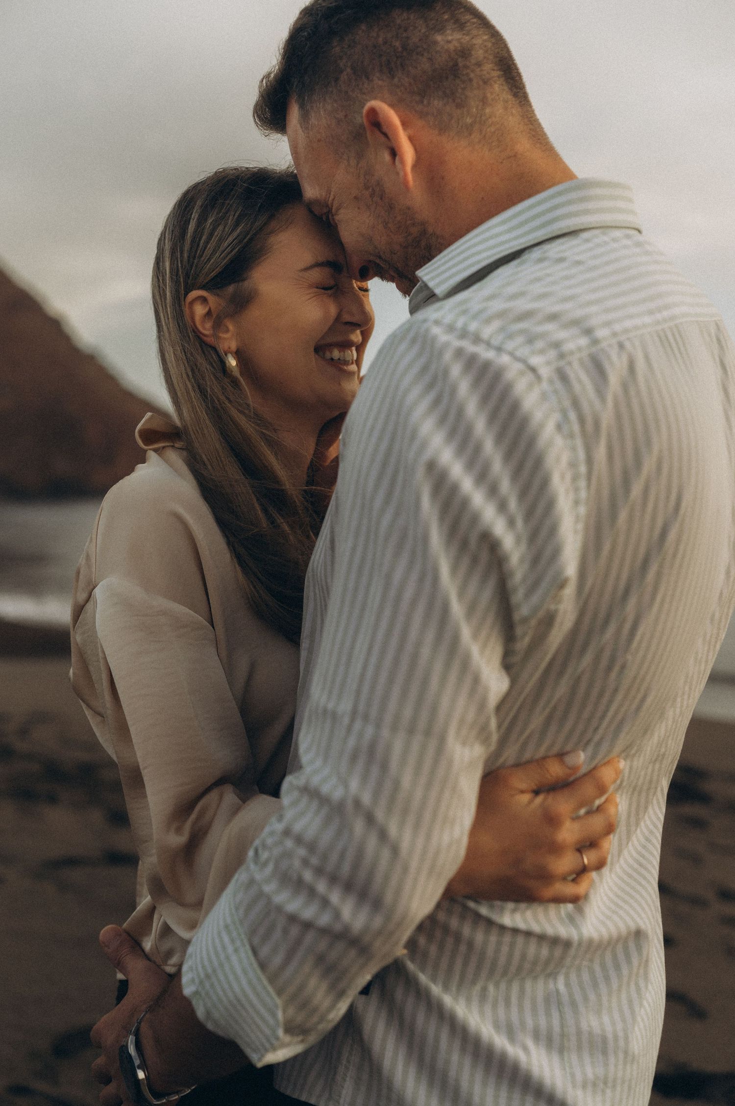 Young couple exchanging tender looks at sunset on Playa de La Tejita, Tenerife