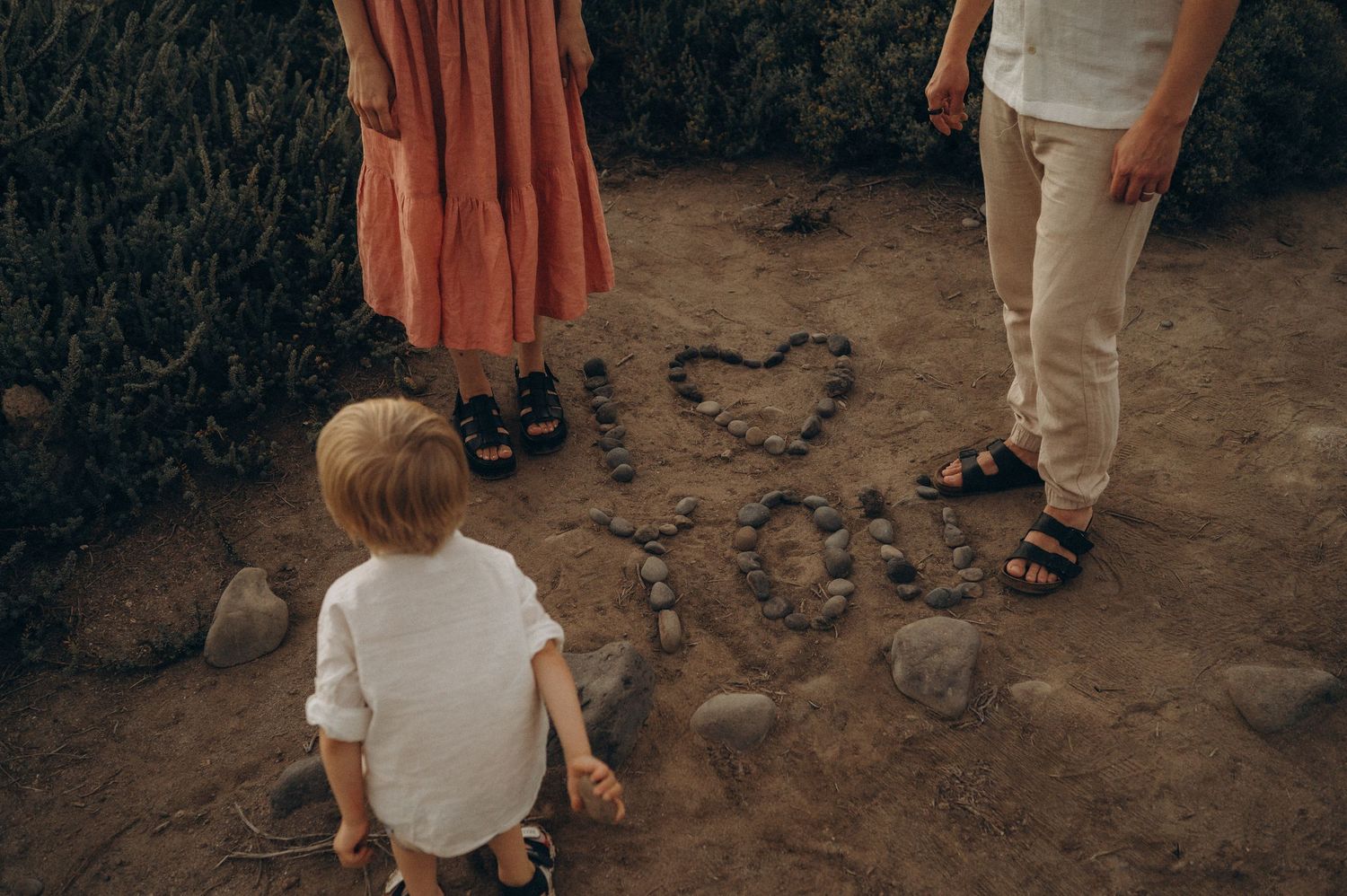 Family on beach with toddler admiring heart drawn in sand, Las Americas Tenerife