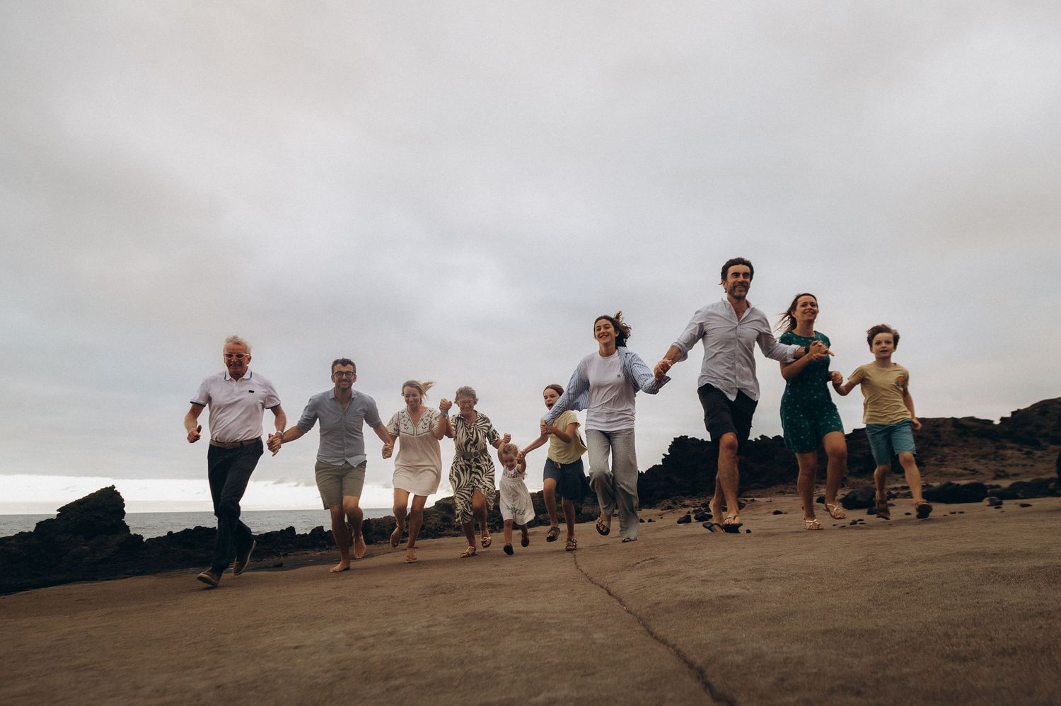 Large family enjoying playful run on volcanic terrain at Los Refugios, Tenerife