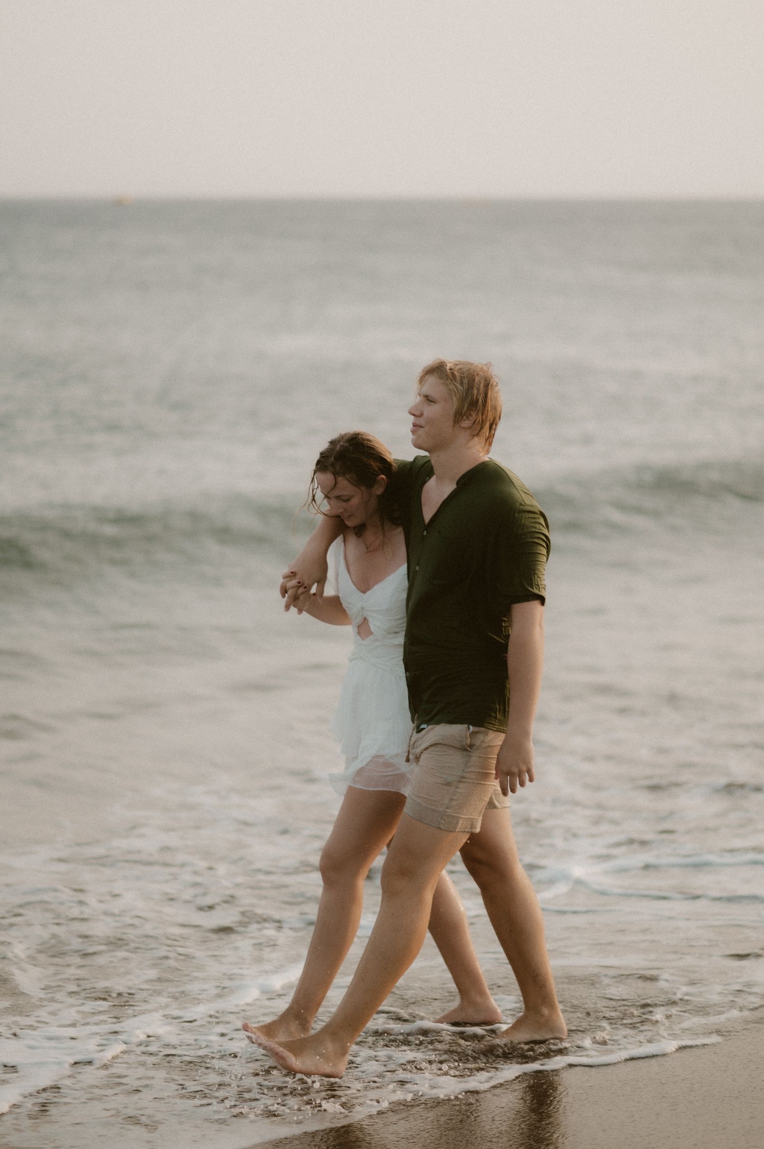 Young couple holding hands and walking along Playa Tejita, Tenerife couples photoshoot