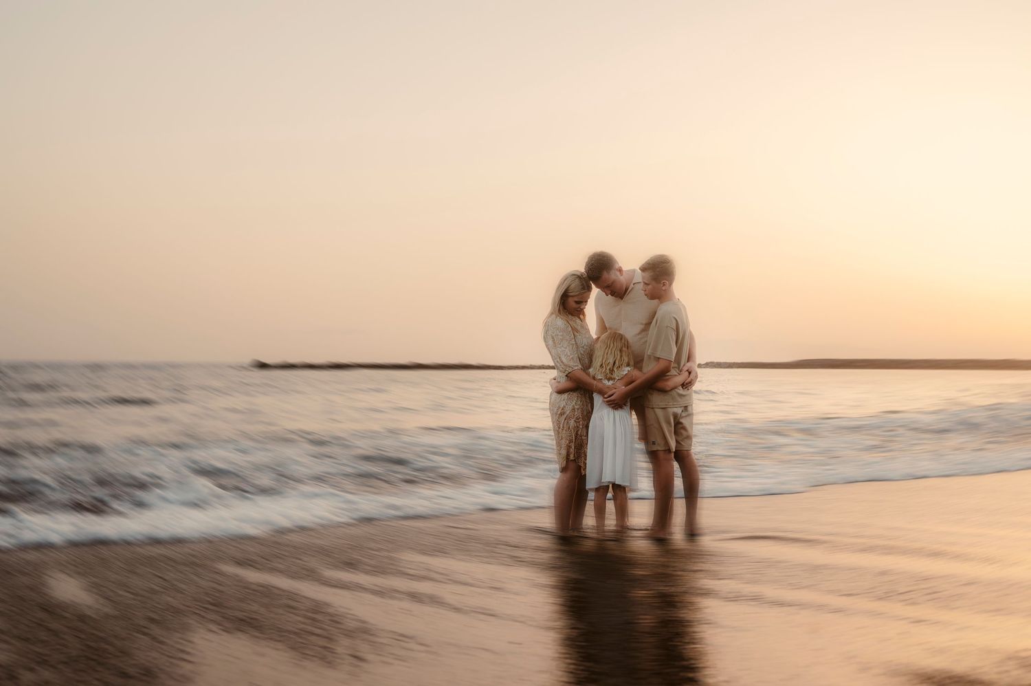Family moment with all members together in arms near Atlantic Ocean