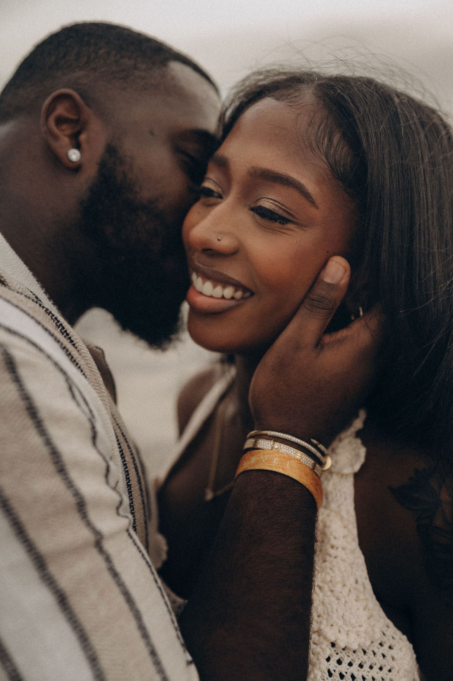 Man kissing woman on cheek as she smiles lovingly