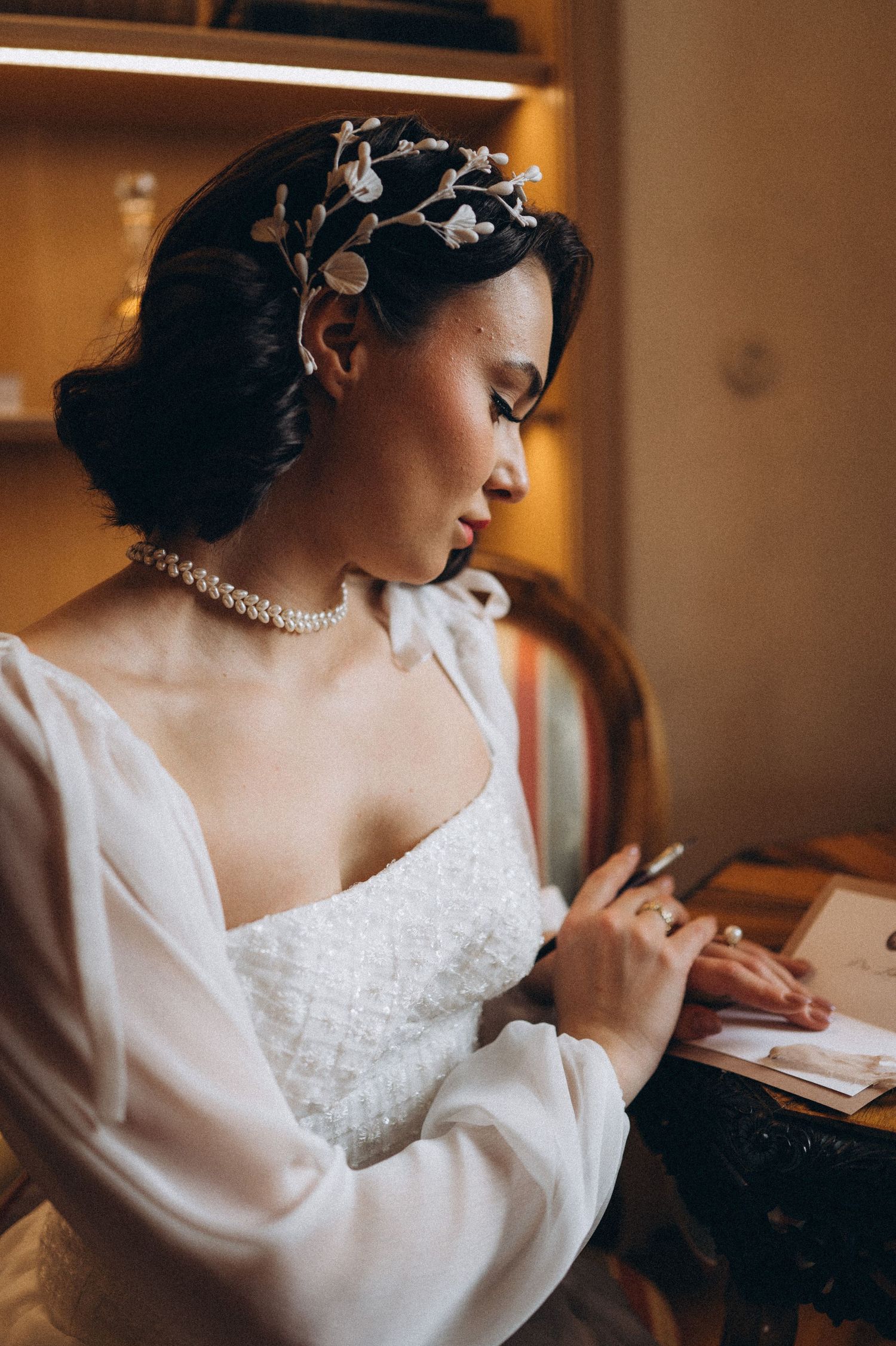 Bride writing her wedding vows, captured from behind with her wedding dress and hairstyle elegantly visible.