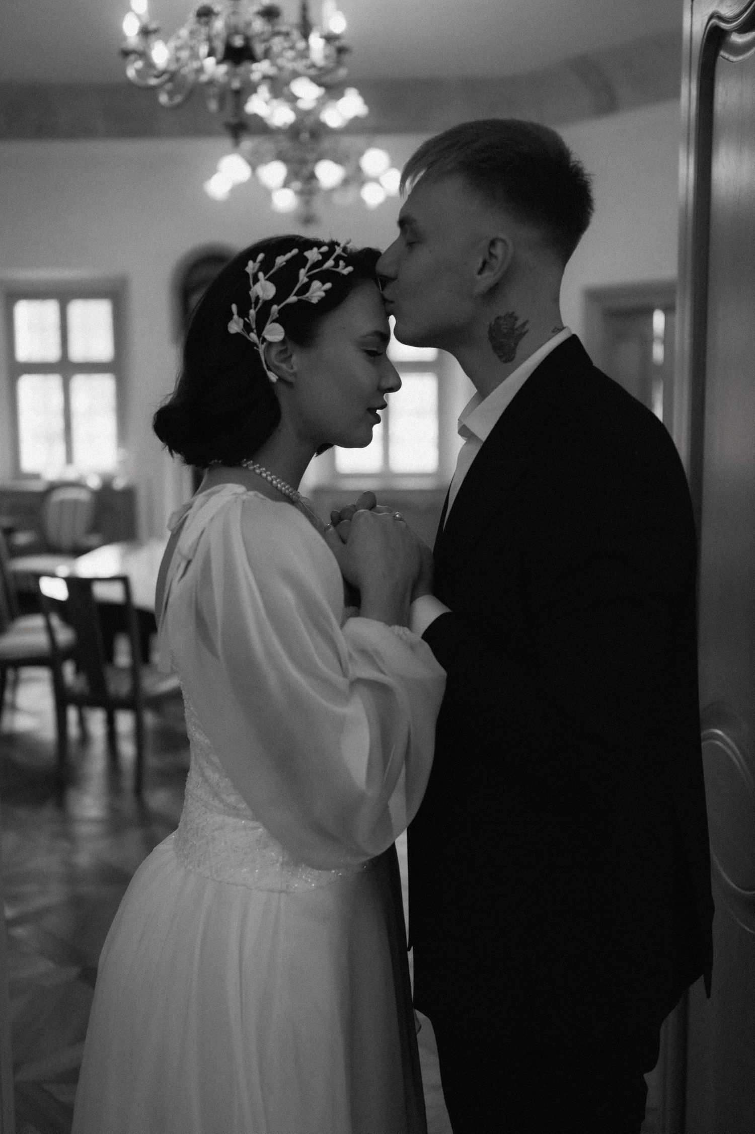 Groom kissing the bride on the forehead during their wedding photoshoot.