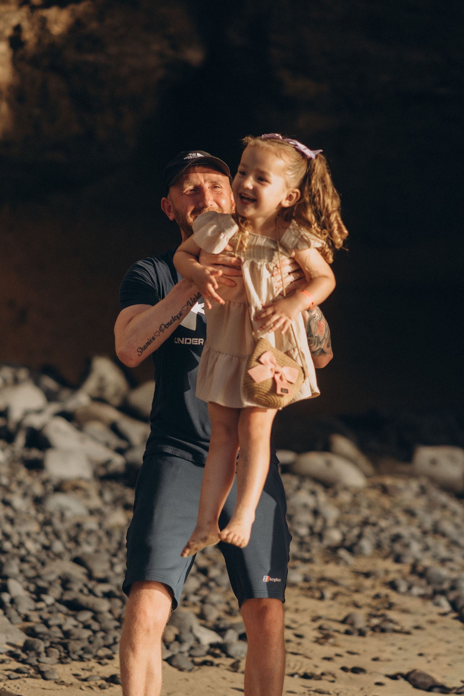 Father holding his daughter during a golden sunset on a Tenerife beach family photoshoot