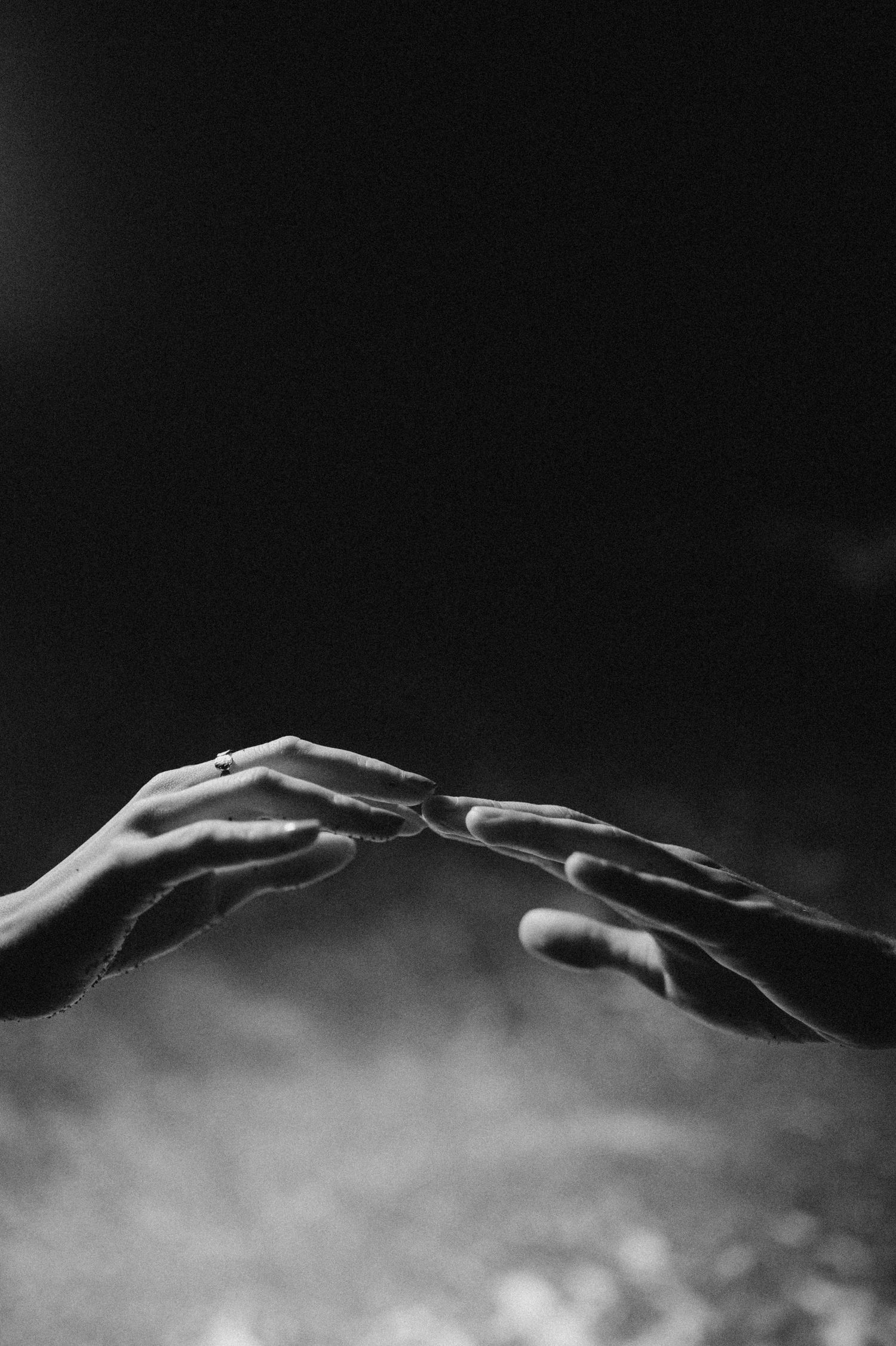 Romantic close-up of her hand with ring around his neck on Playa de La Tejita, Tenerife