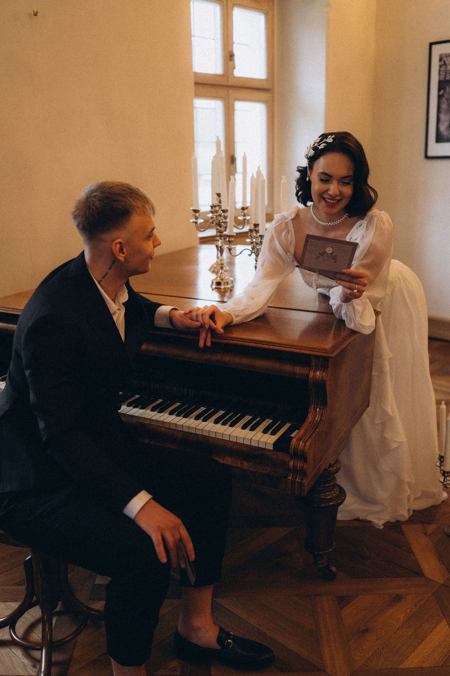Bride and groom sharing an intimate moment at a piano, admiring each other during their wedding photoshoot.