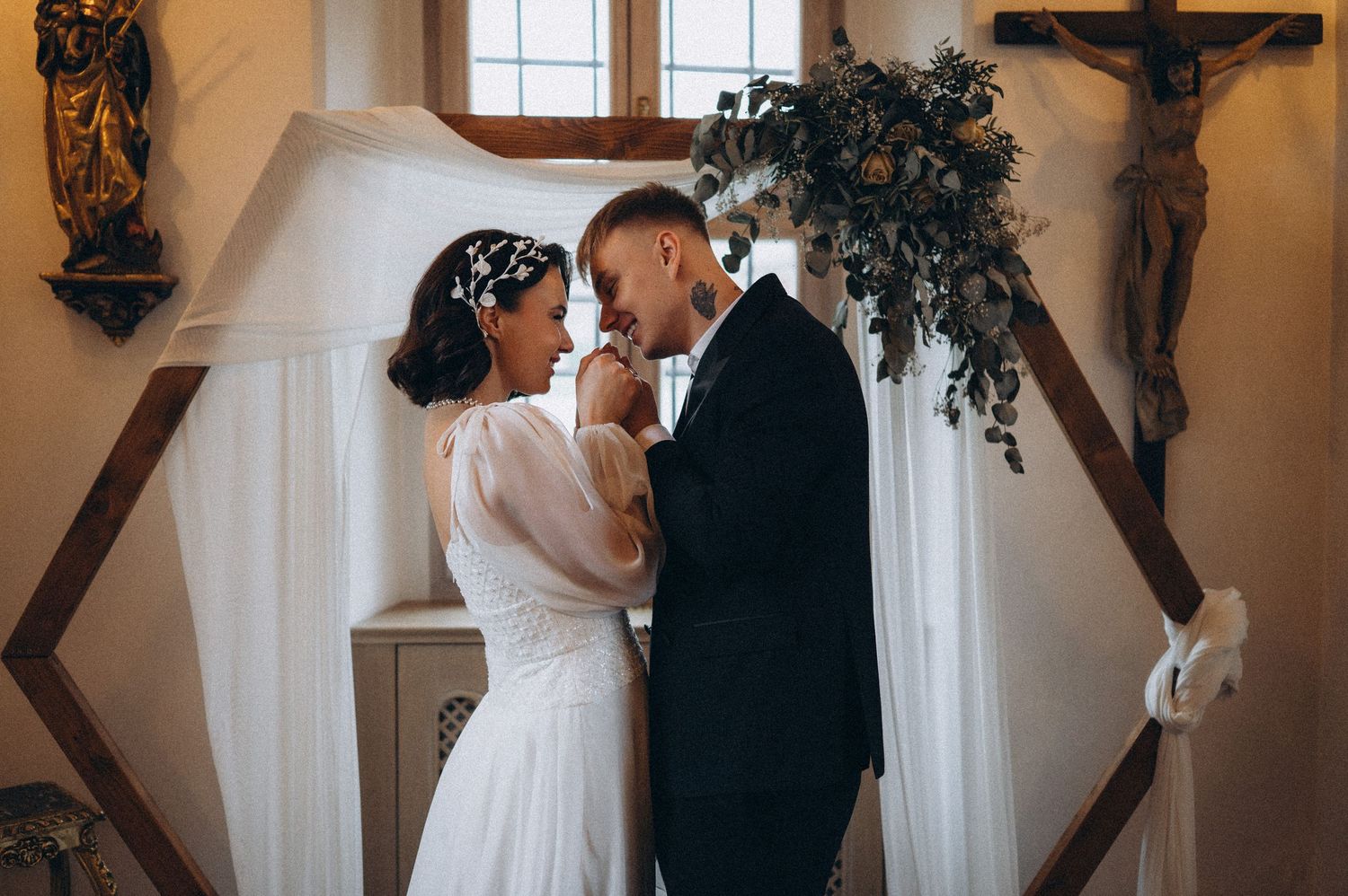 Bride and groom reflected in a mirror as he kisses her hand, highlighting her wedding ring, wedding ring detail.